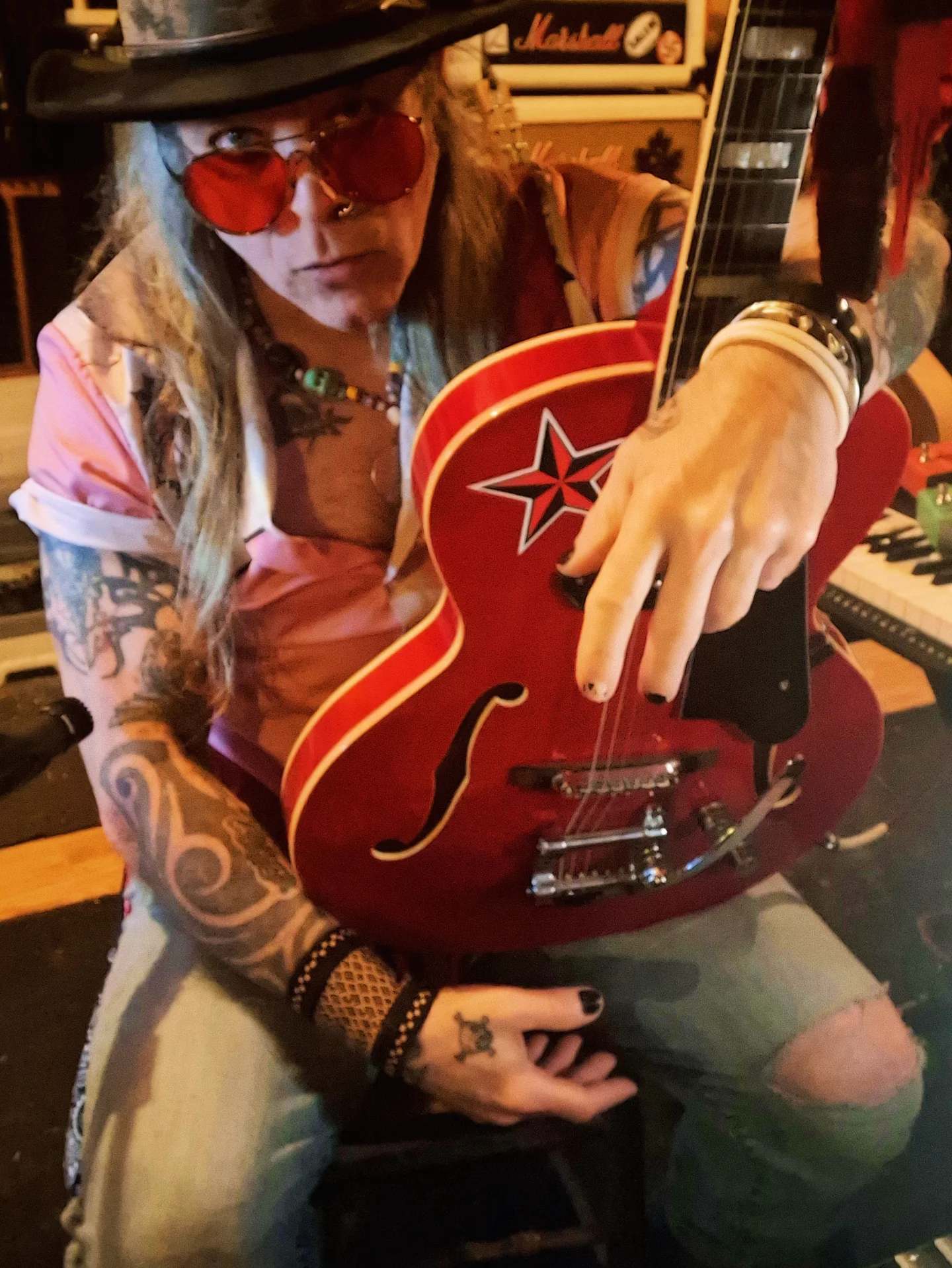 a man in a hat with a red guitar