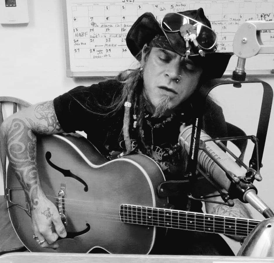 a black and white photo of a man playing an acoustic guitar