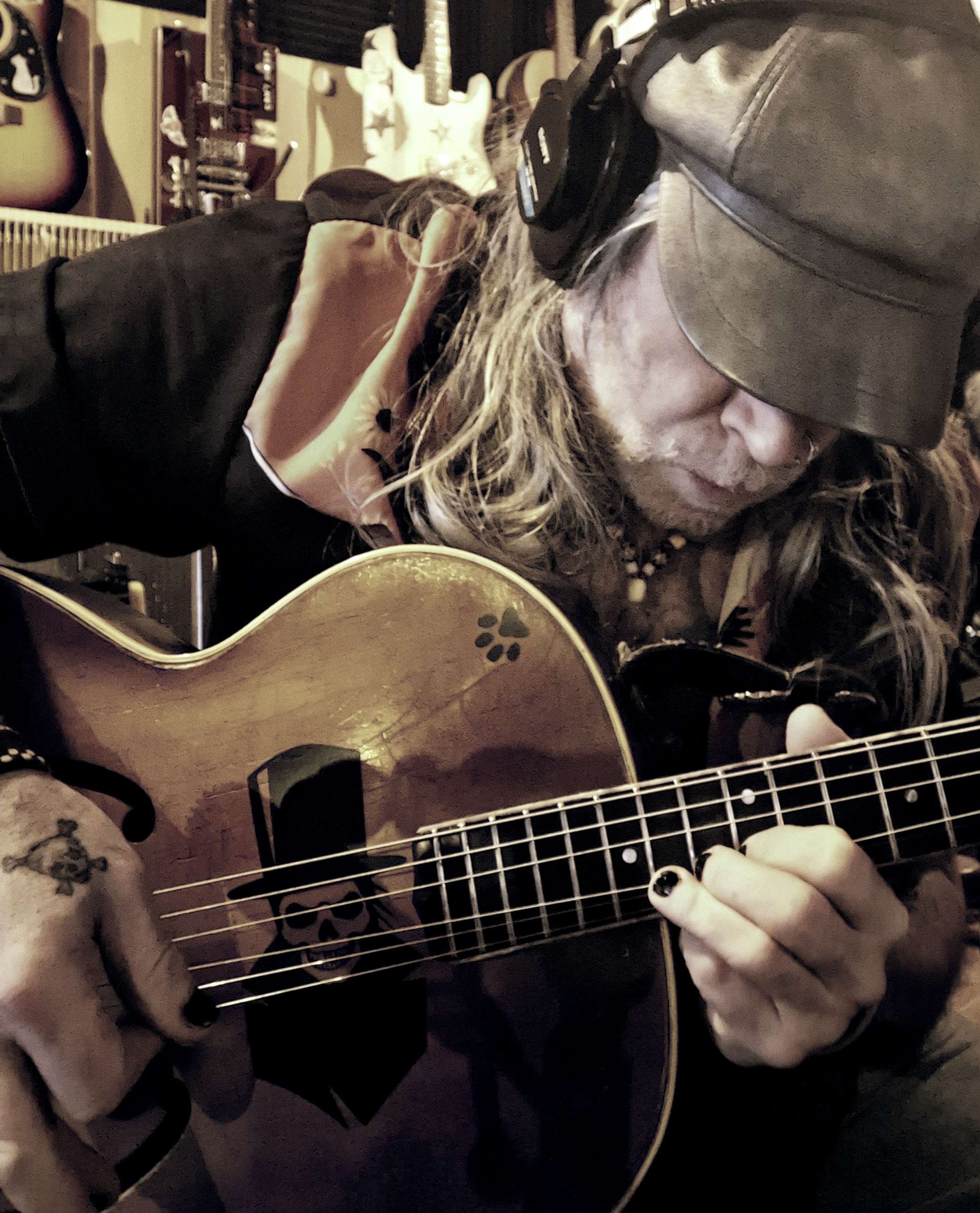 a man in a hat playing an acoustic guitar