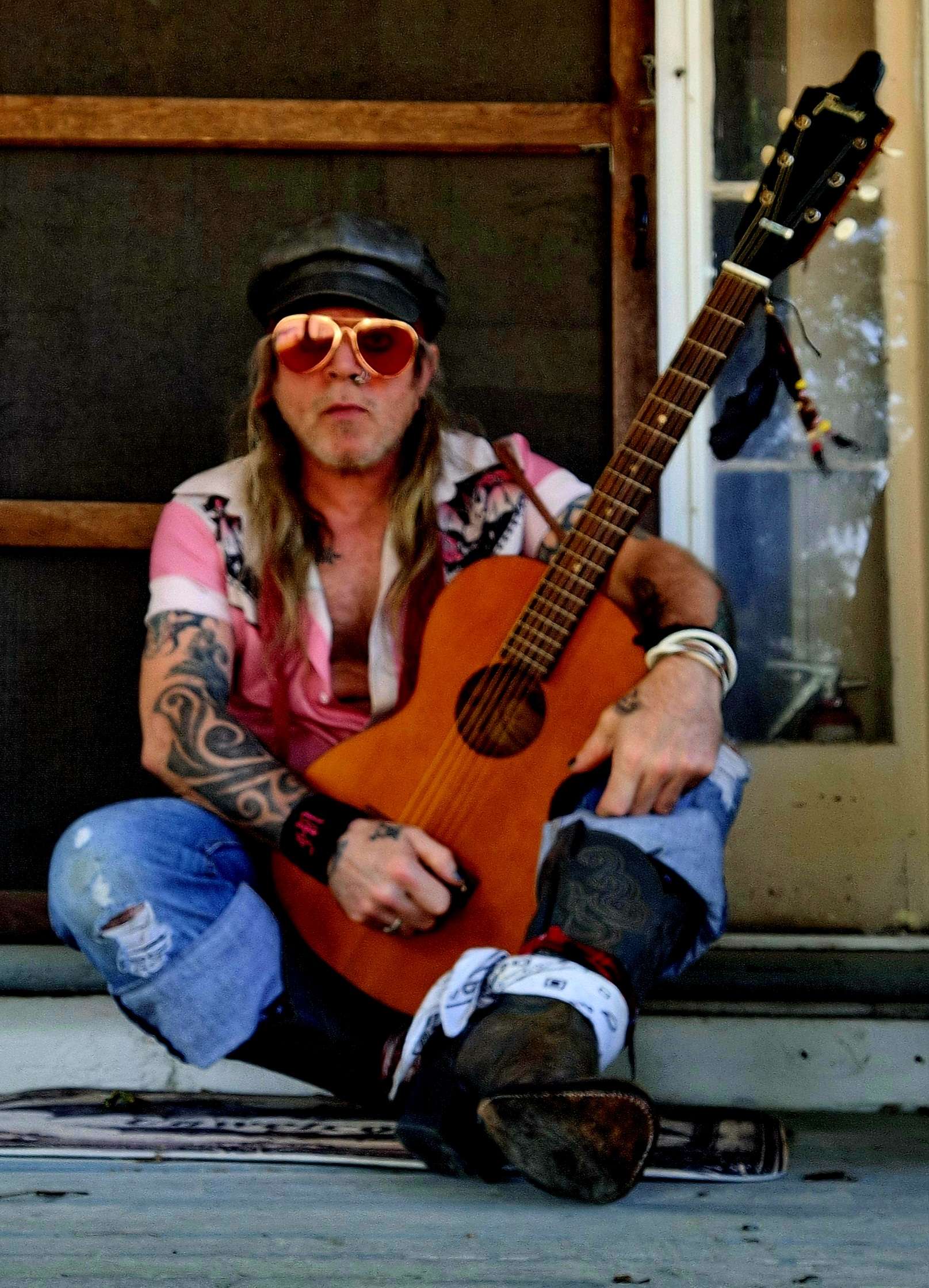 a man sitting on the porch with a guitar