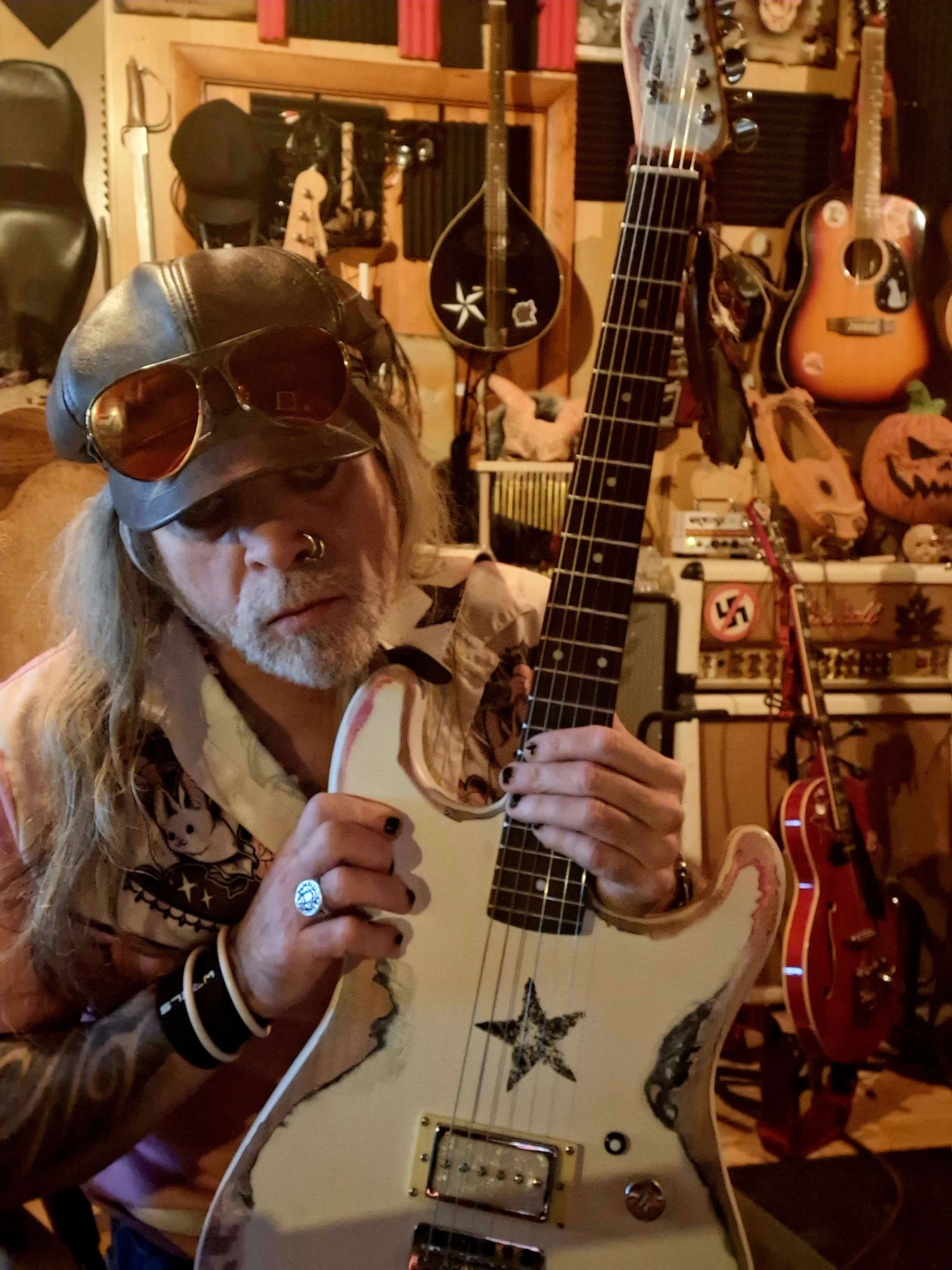 a man in a hat is holding a guitar