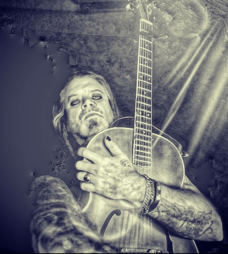 a black and white photo of a man holding a guitar