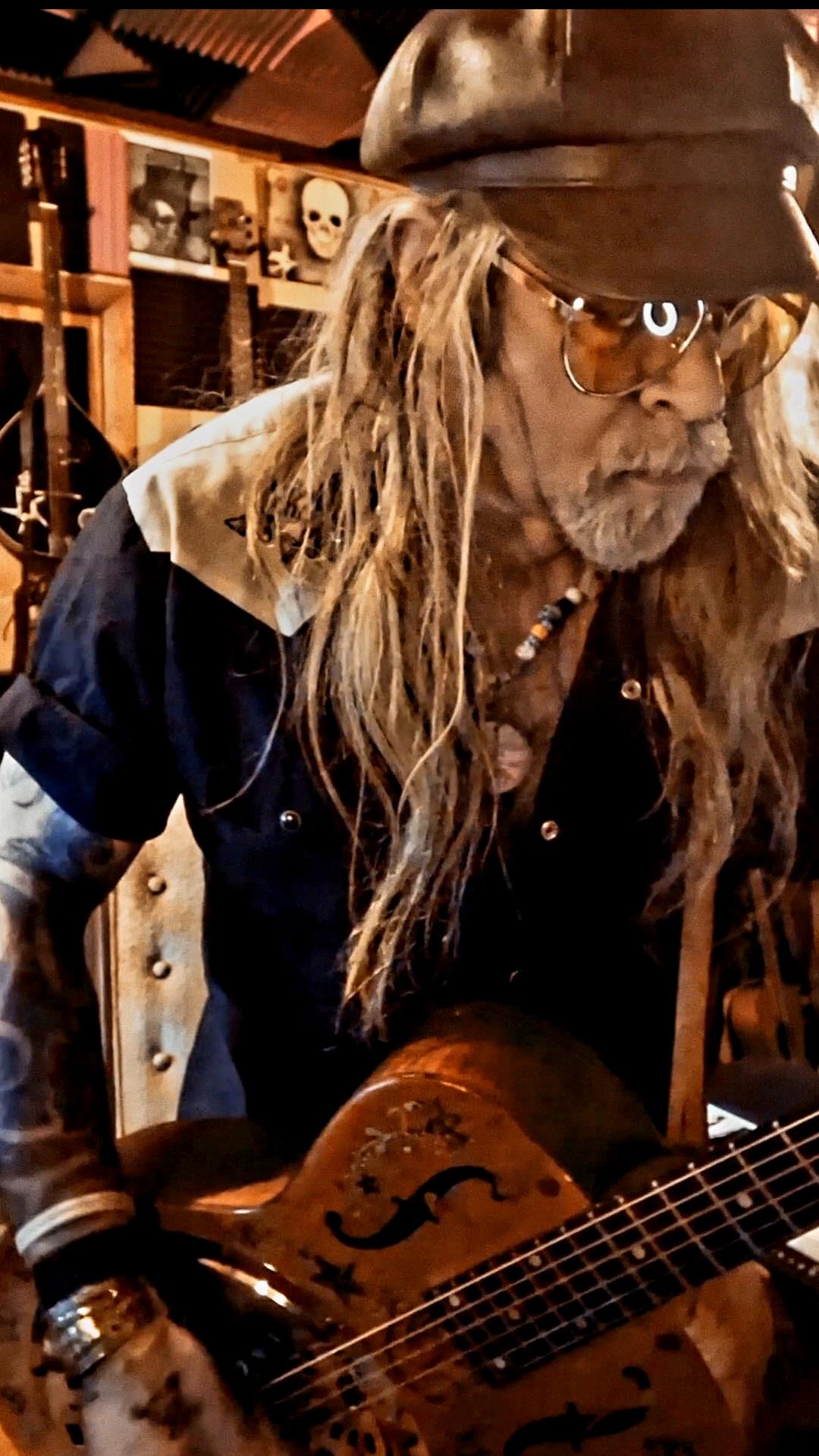 a man with long hair playing a guitar