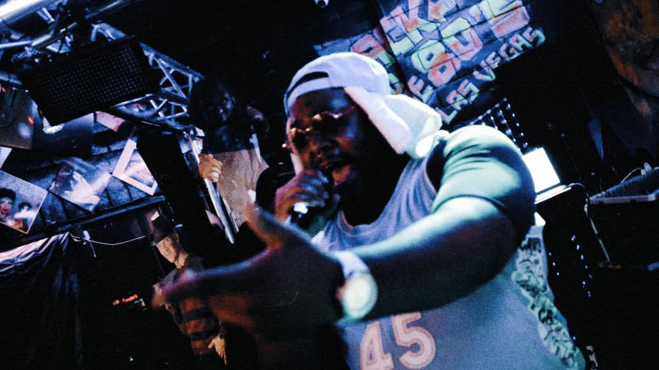 a man in a hat singing into a microphone