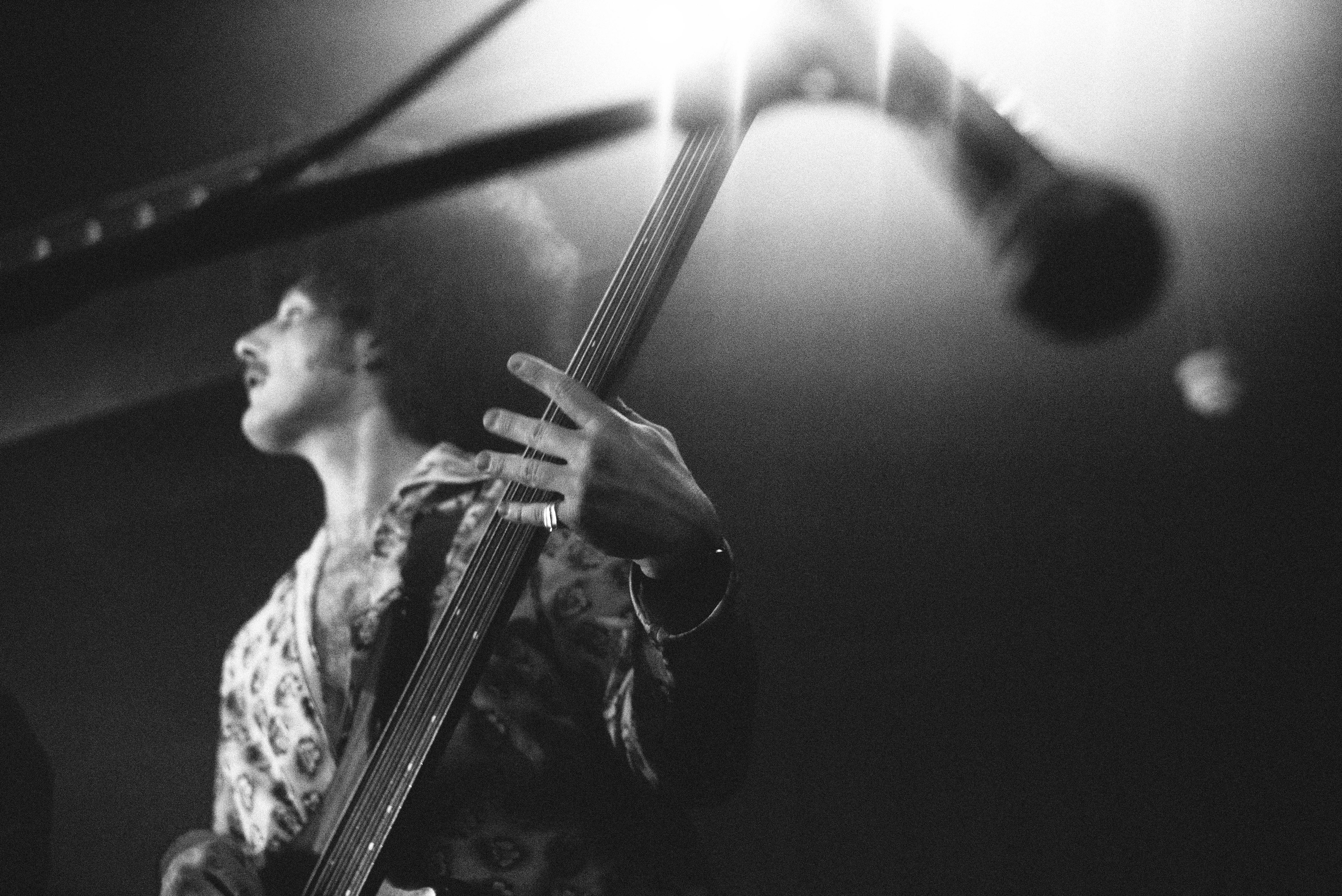a black and white photo of a man playing a bass