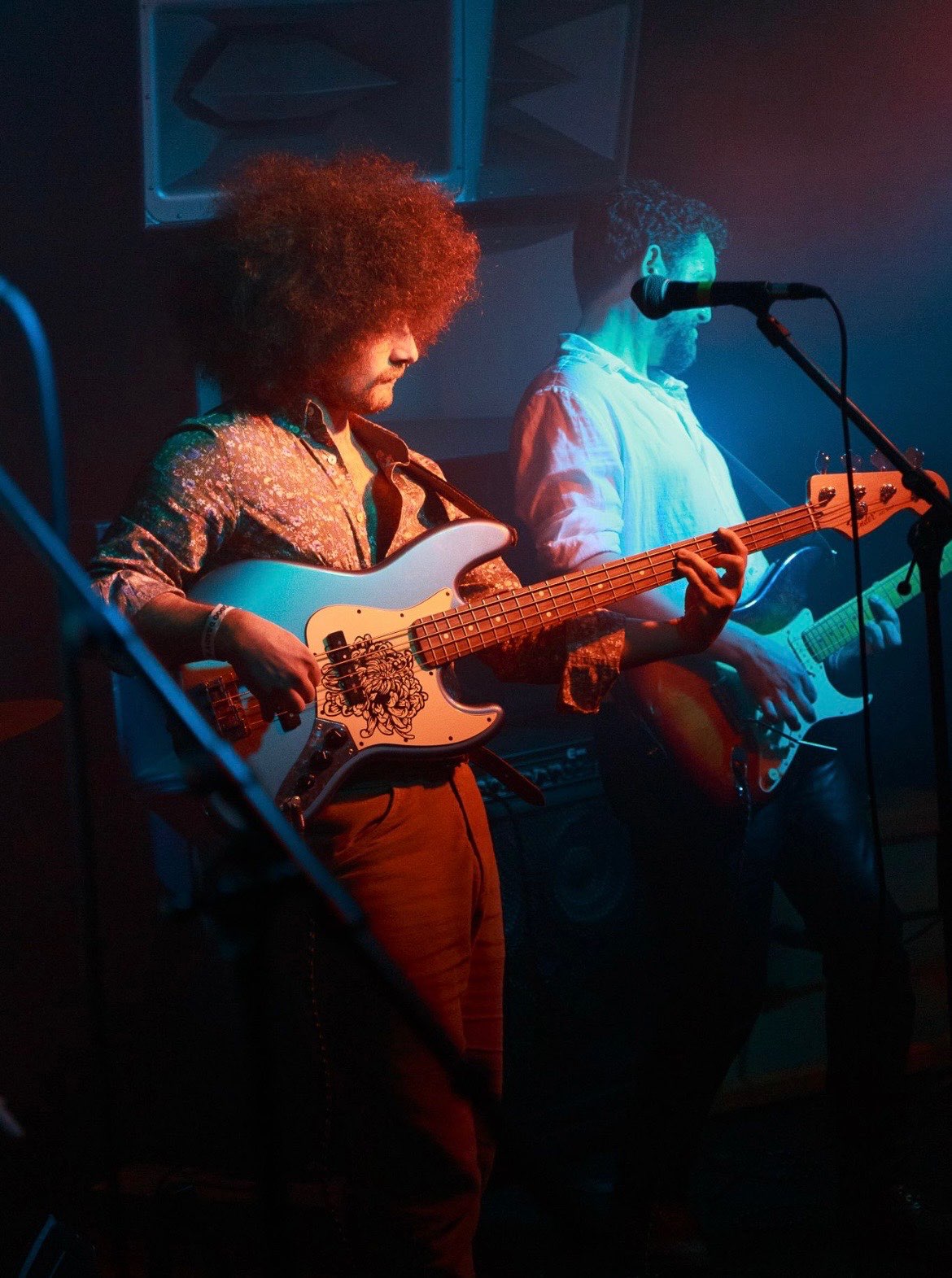 a group of people playing guitars in front of a microphone