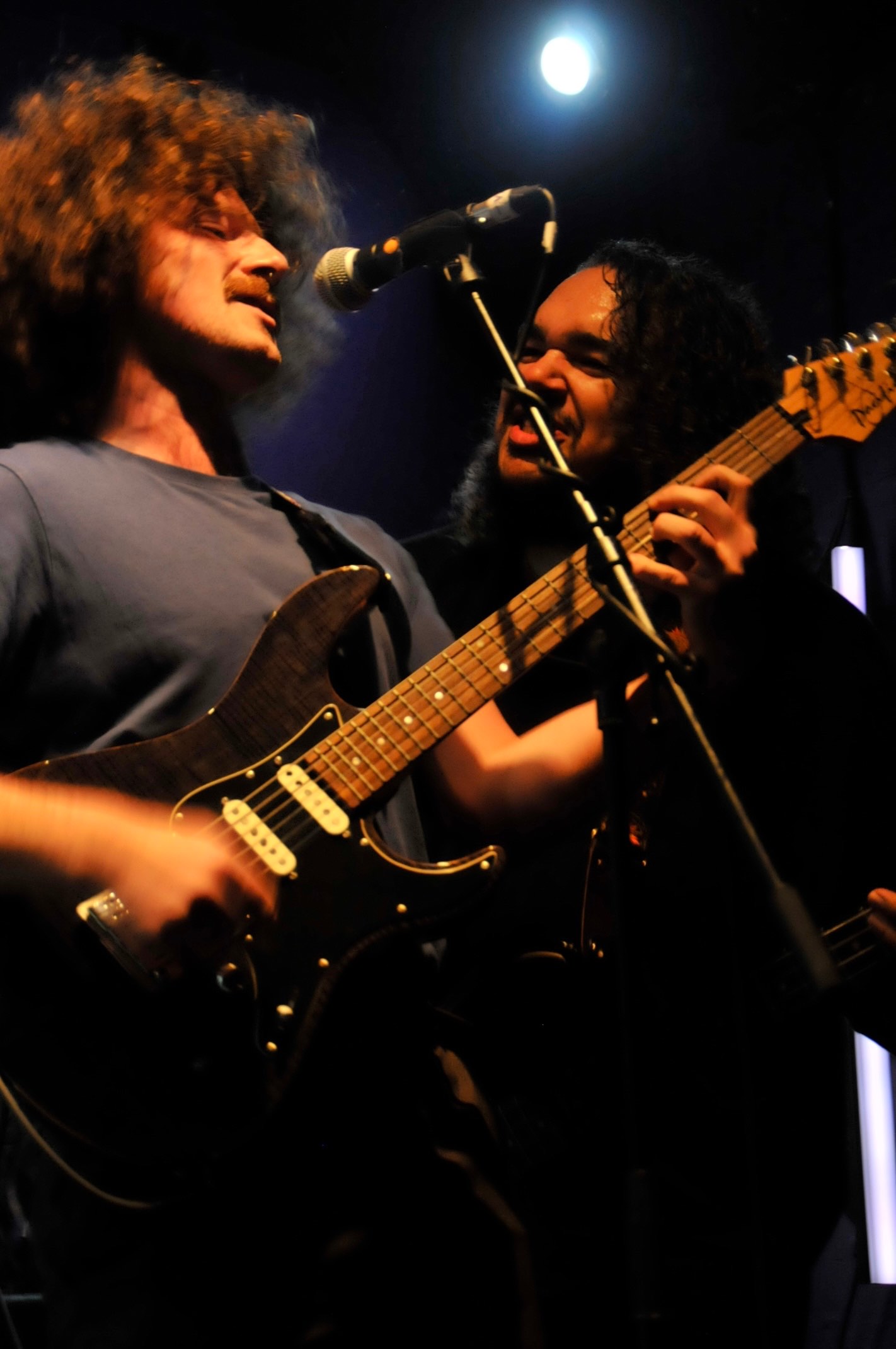 a man playing a guitar in front of a microphone