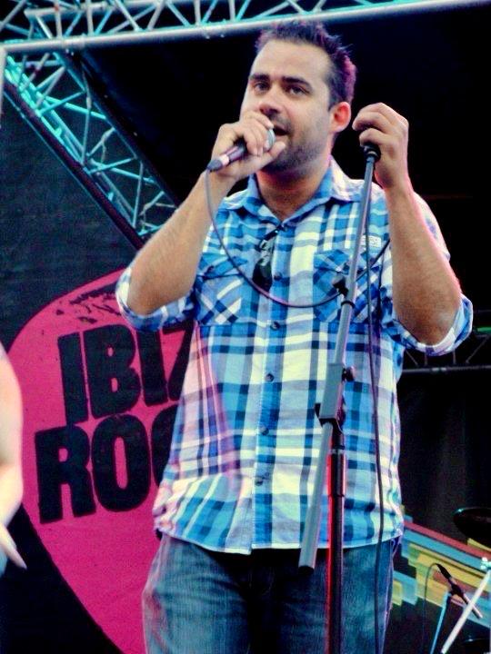 a man singing into a microphone on stage
