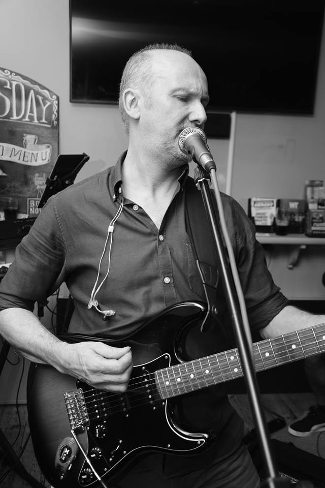 image may contain person, playing a musical instrument, on stage and guitar