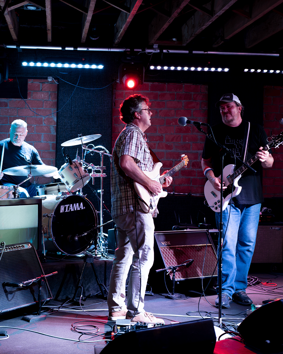 a group of men playing guitars on stage