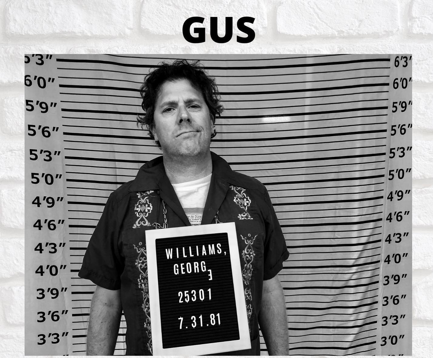 a man holding up a mugshot with the words gus