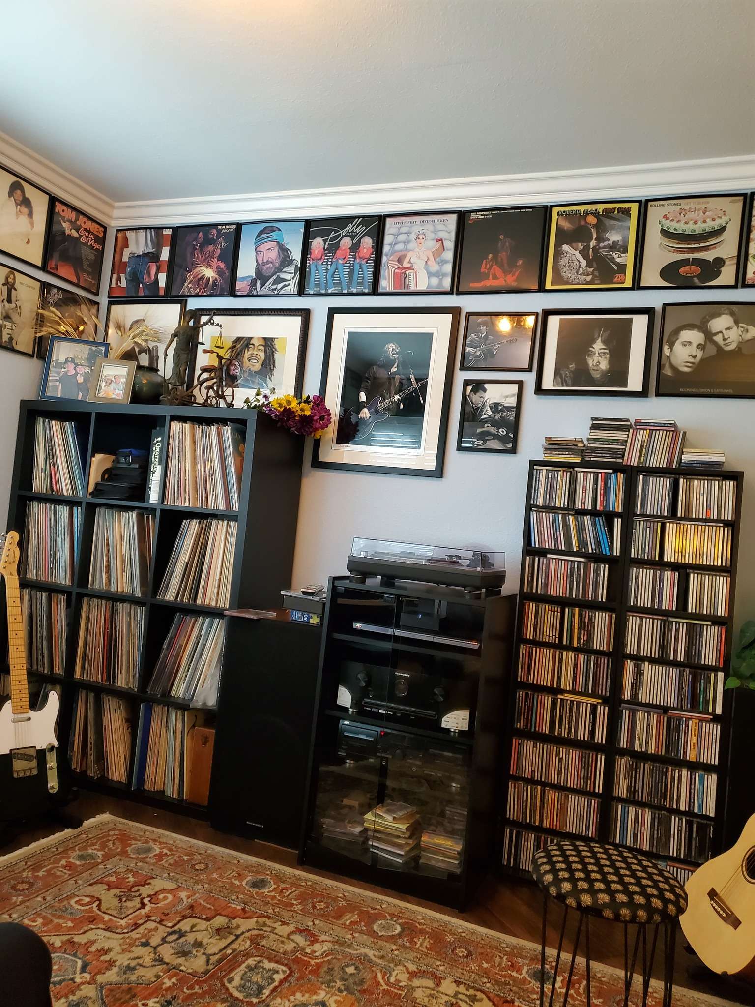 a room with a lot of cds, records and guitars