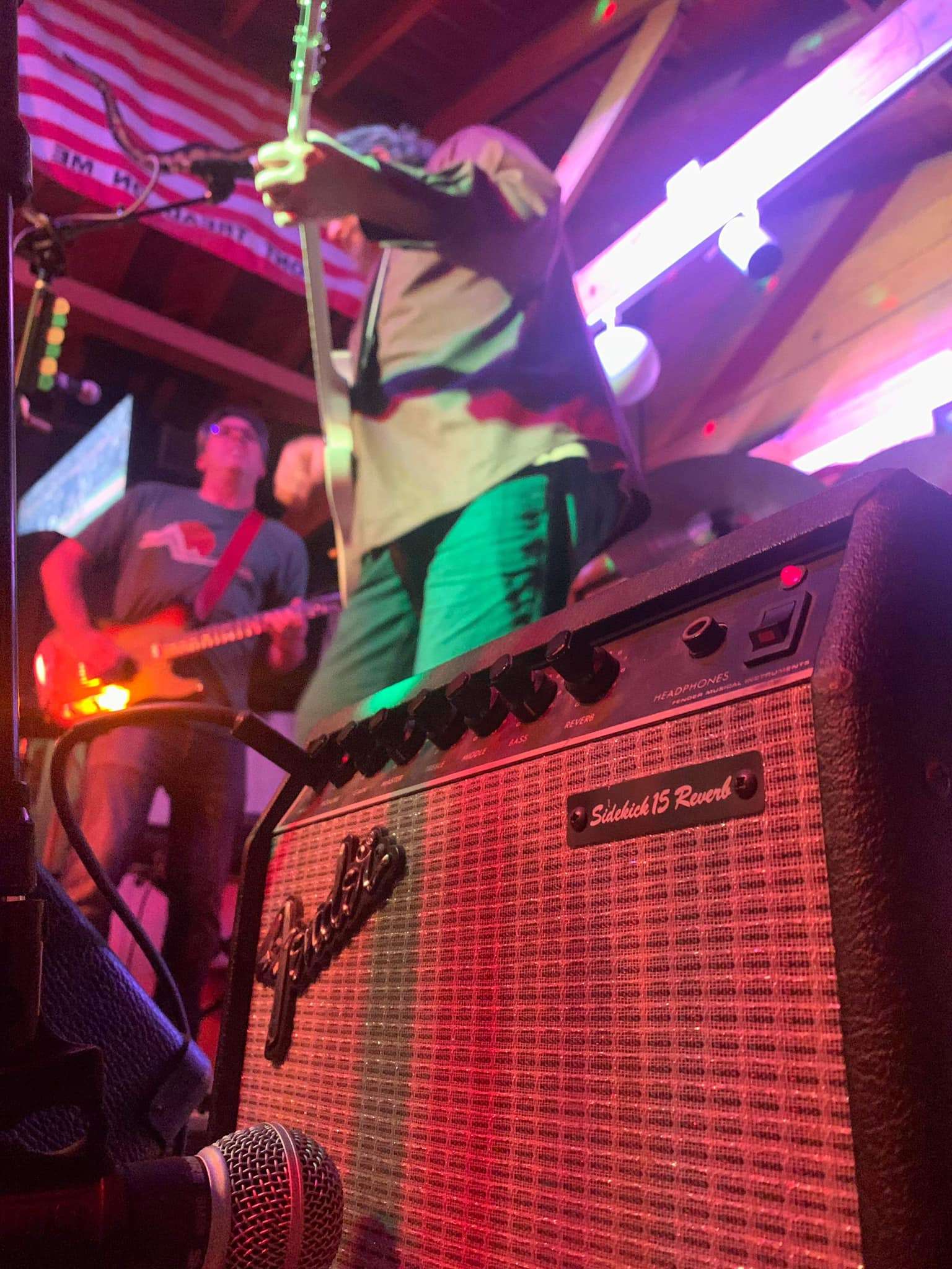 a man is playing a guitar in front of a microphone