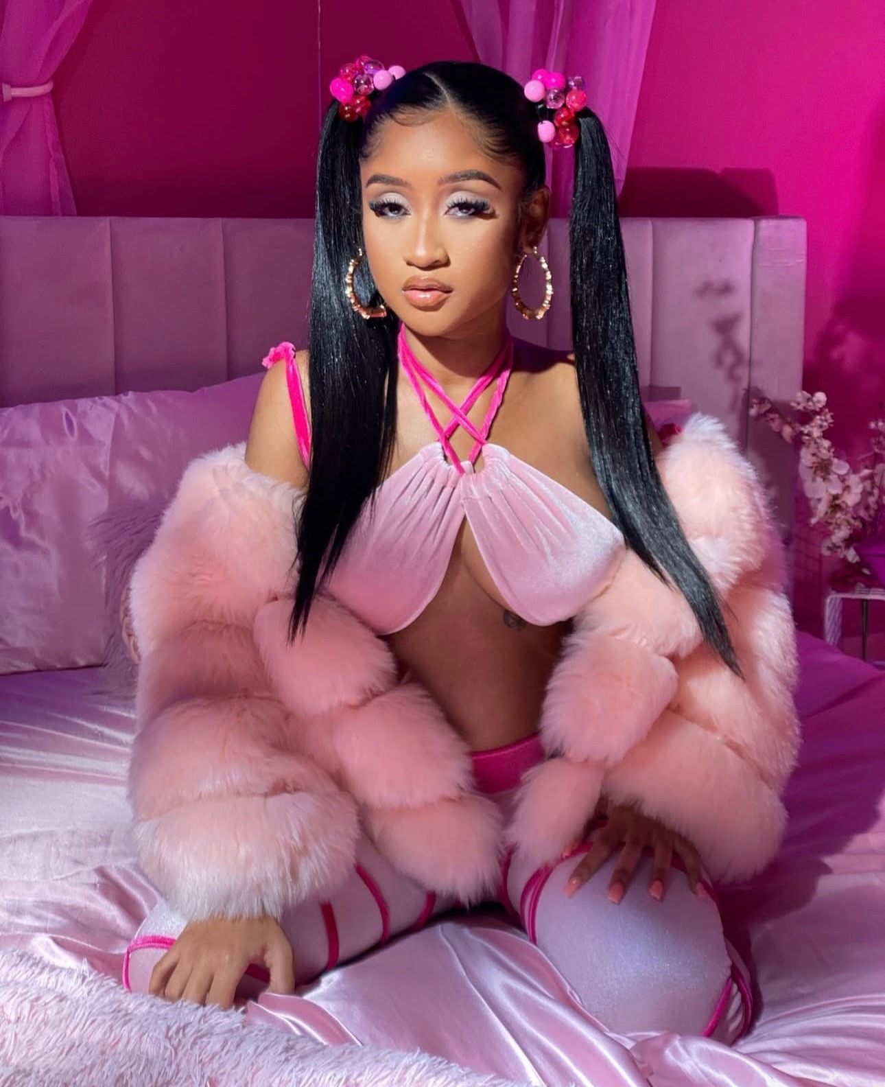 a woman in pink sitting on a bed