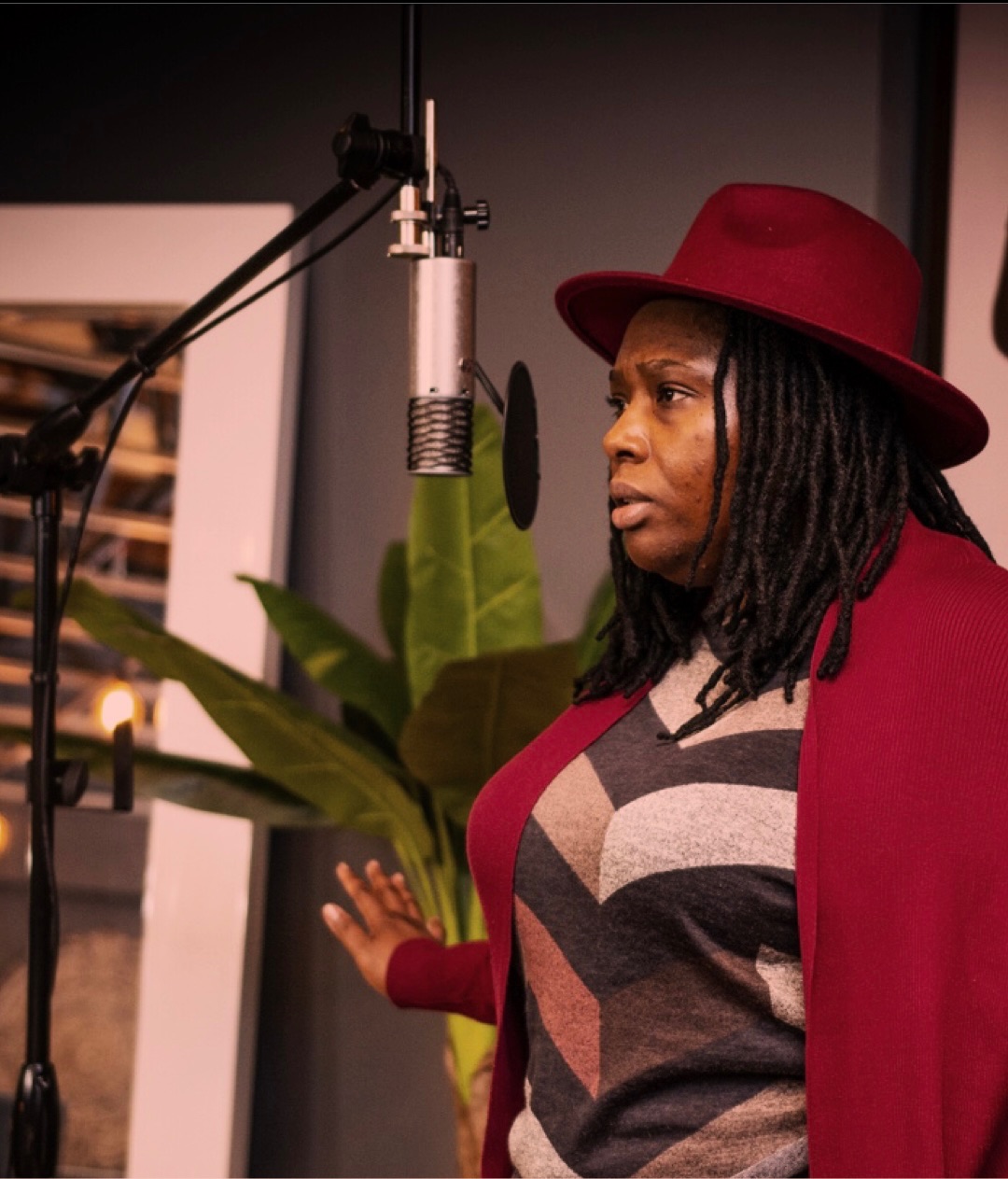 a woman in a red hat is standing in front of a microphone