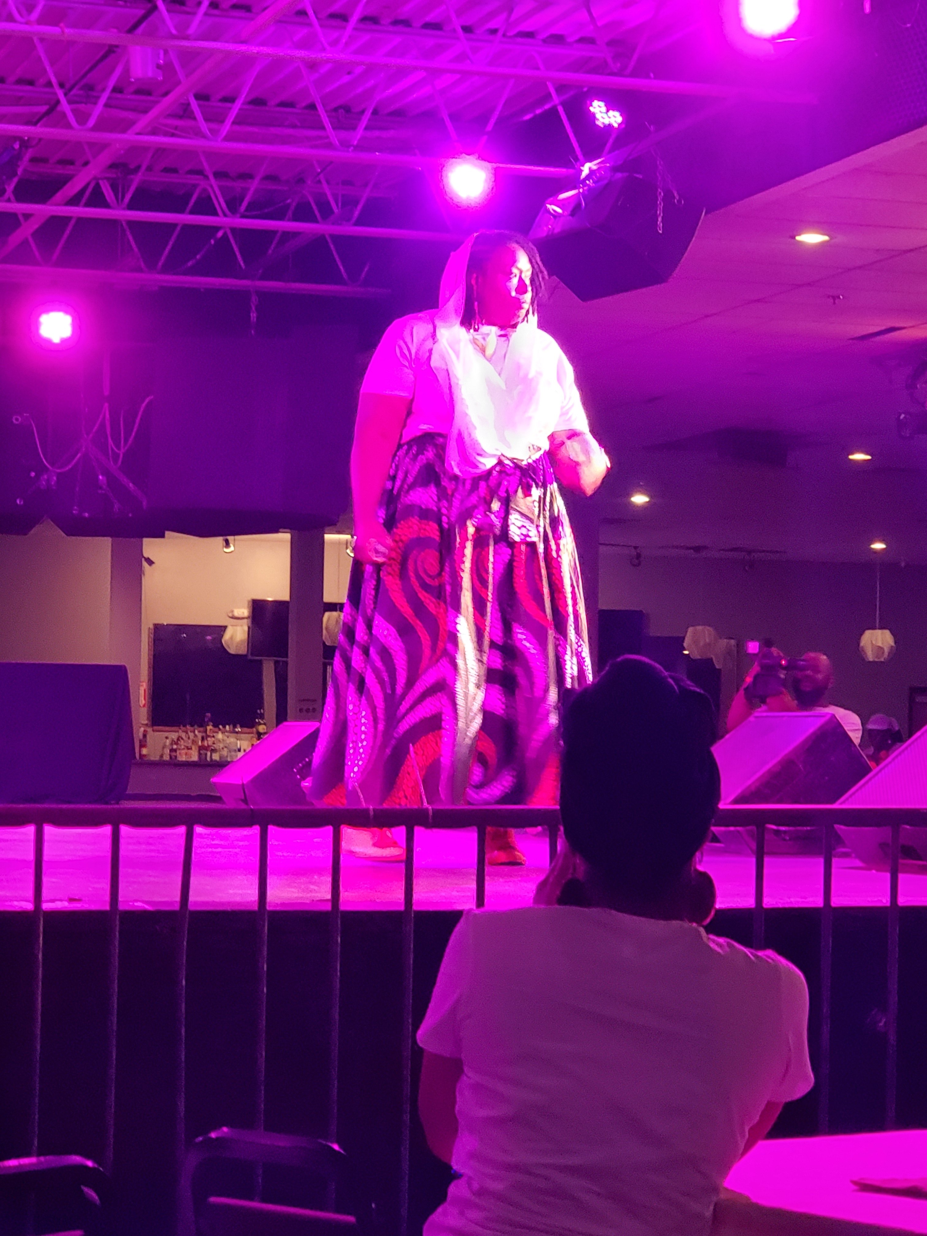 a woman on a stage in front of a purple light