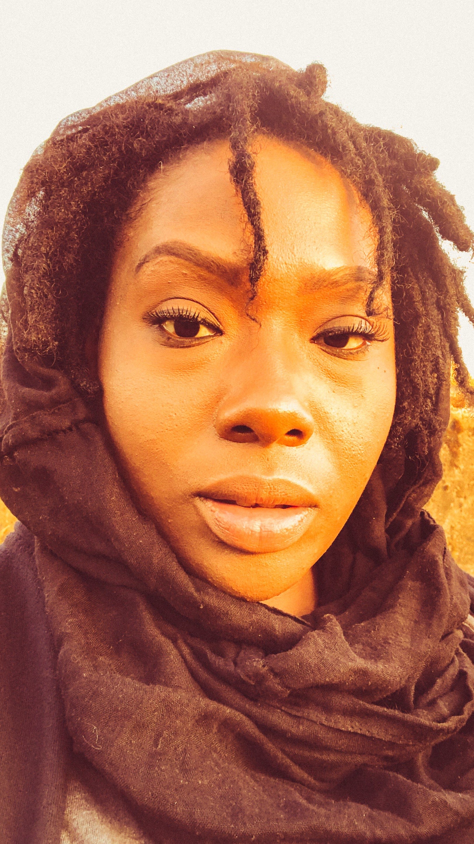 a black woman with dreadlocks and a scarf