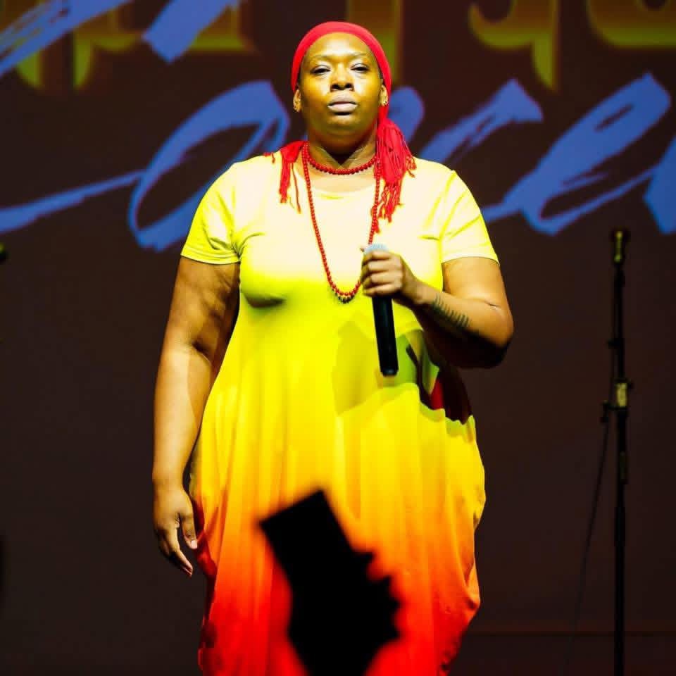 a woman in a yellow dress singing on stage