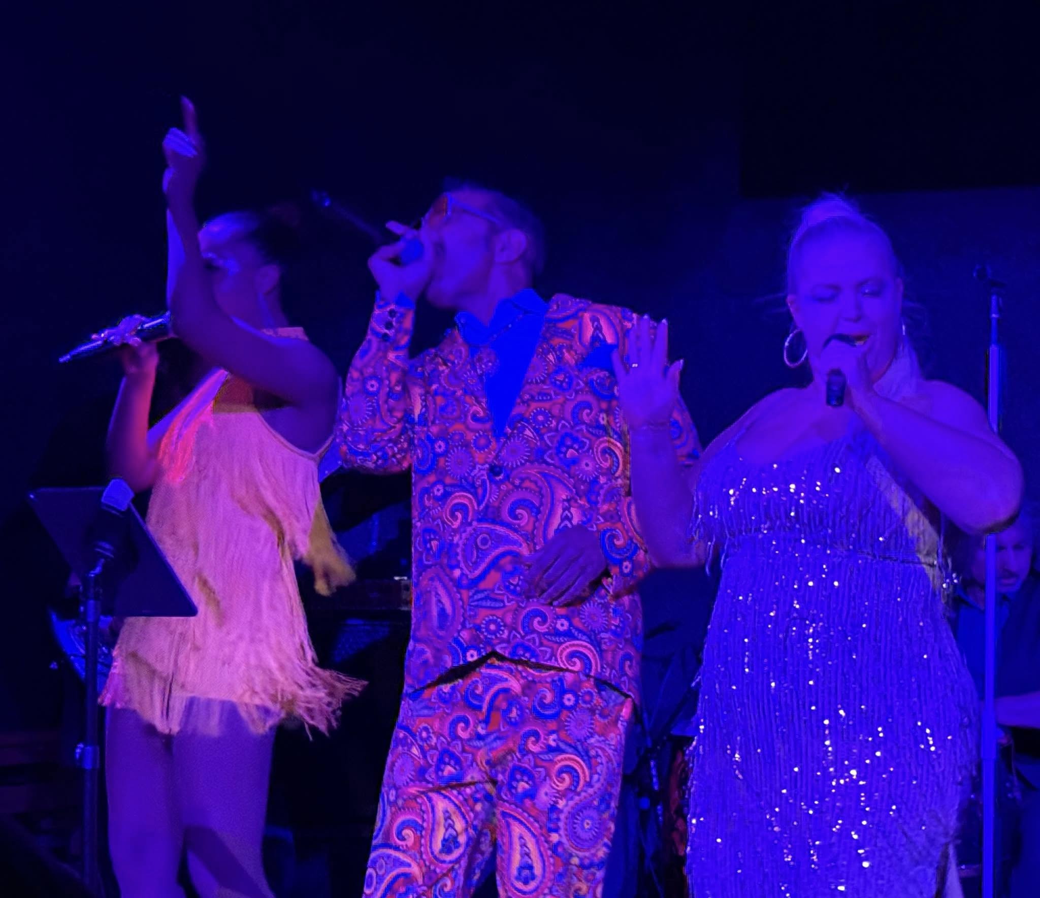 a group of people singing on stage at a concert