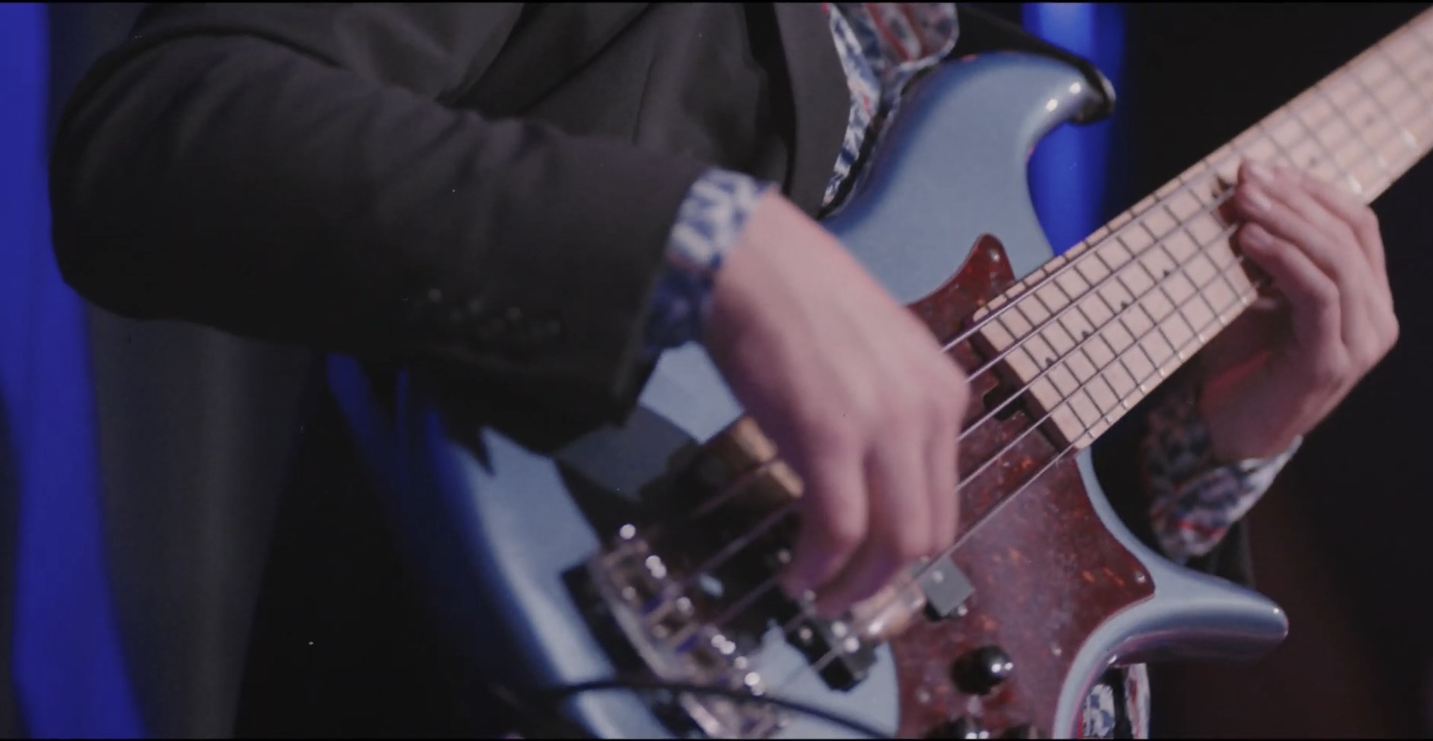 a person playing a blue bass on stage