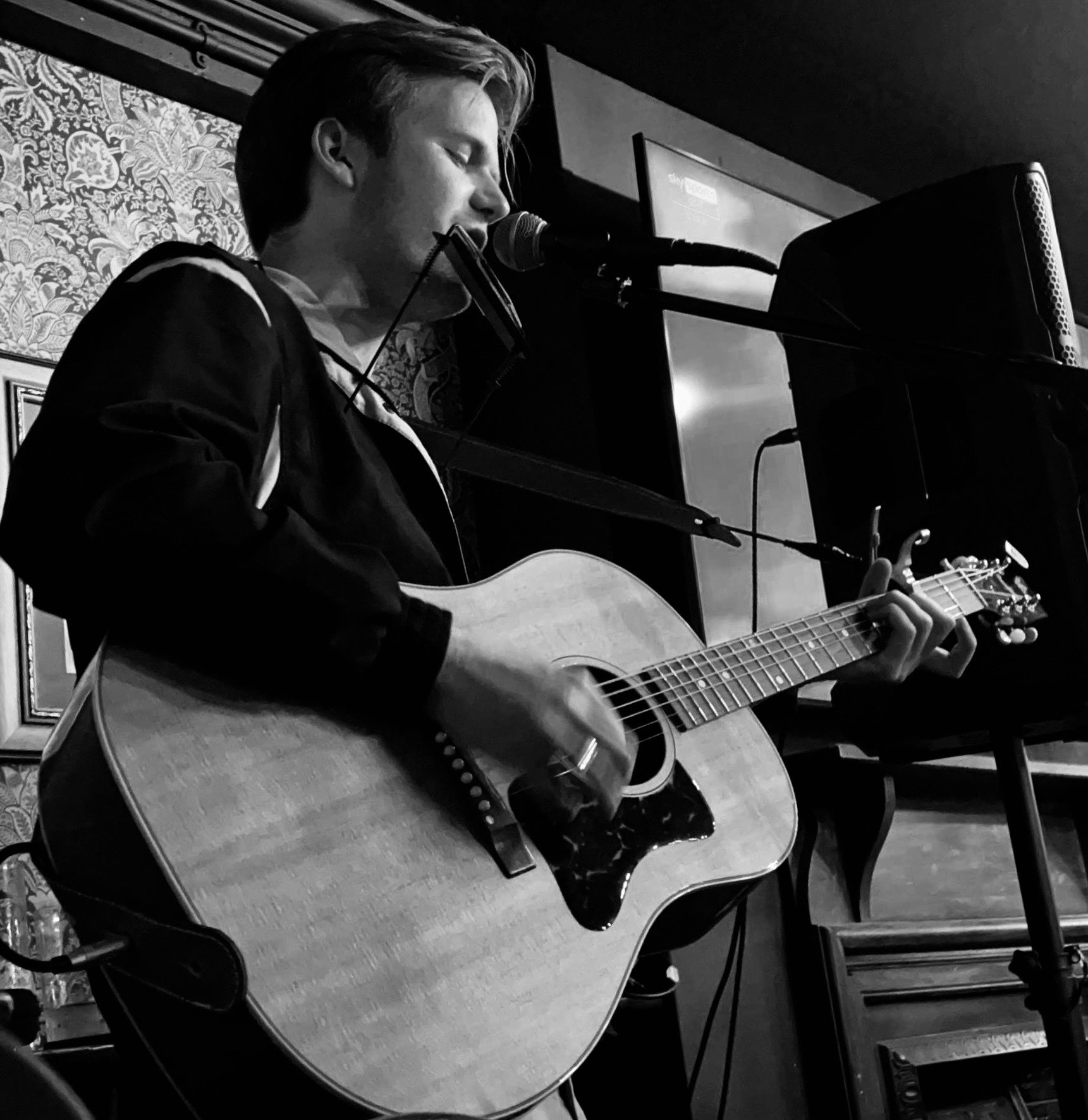 image may contain person, playing a musical instrument, on stage and guitar