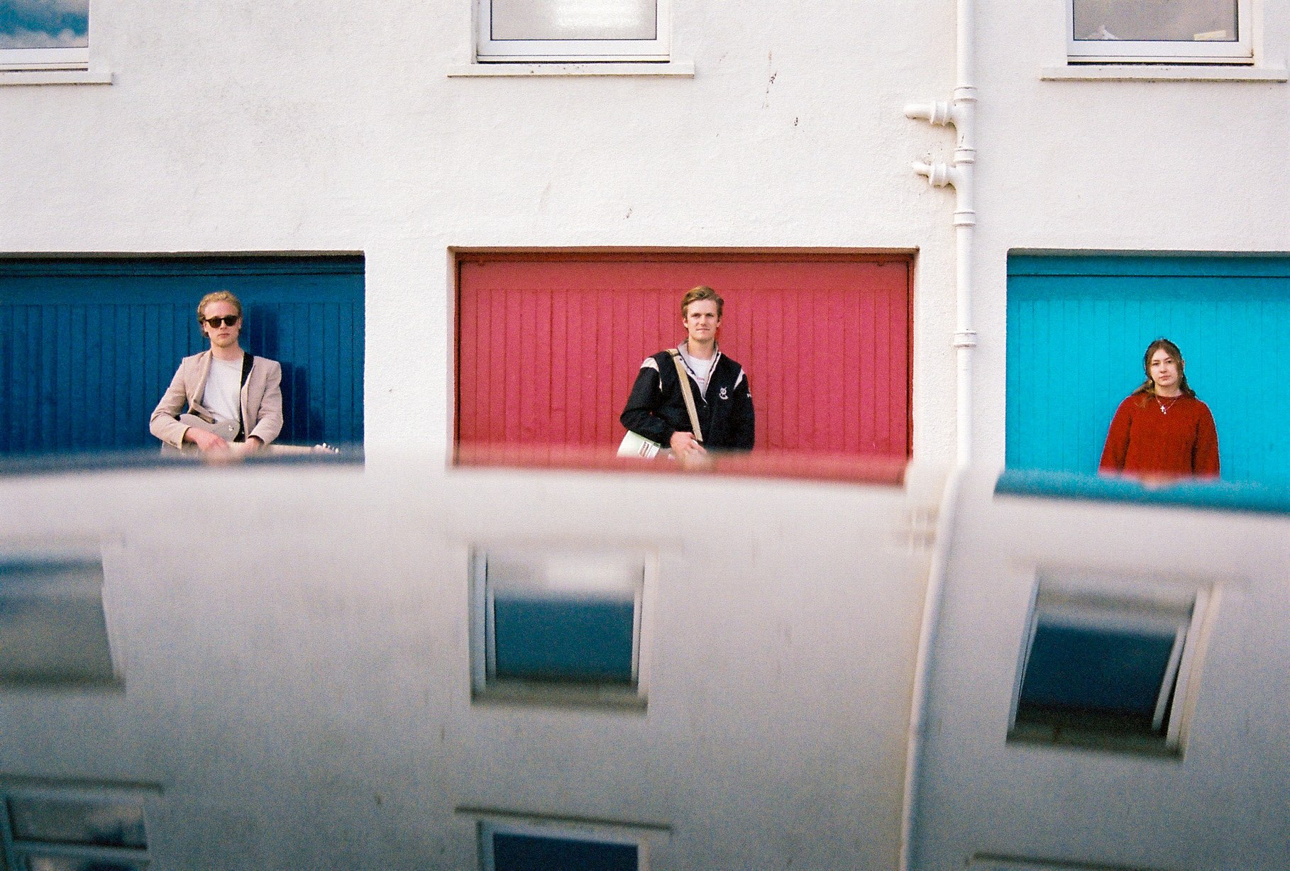three people standing in front of a building