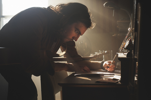 a man writing on a desk
