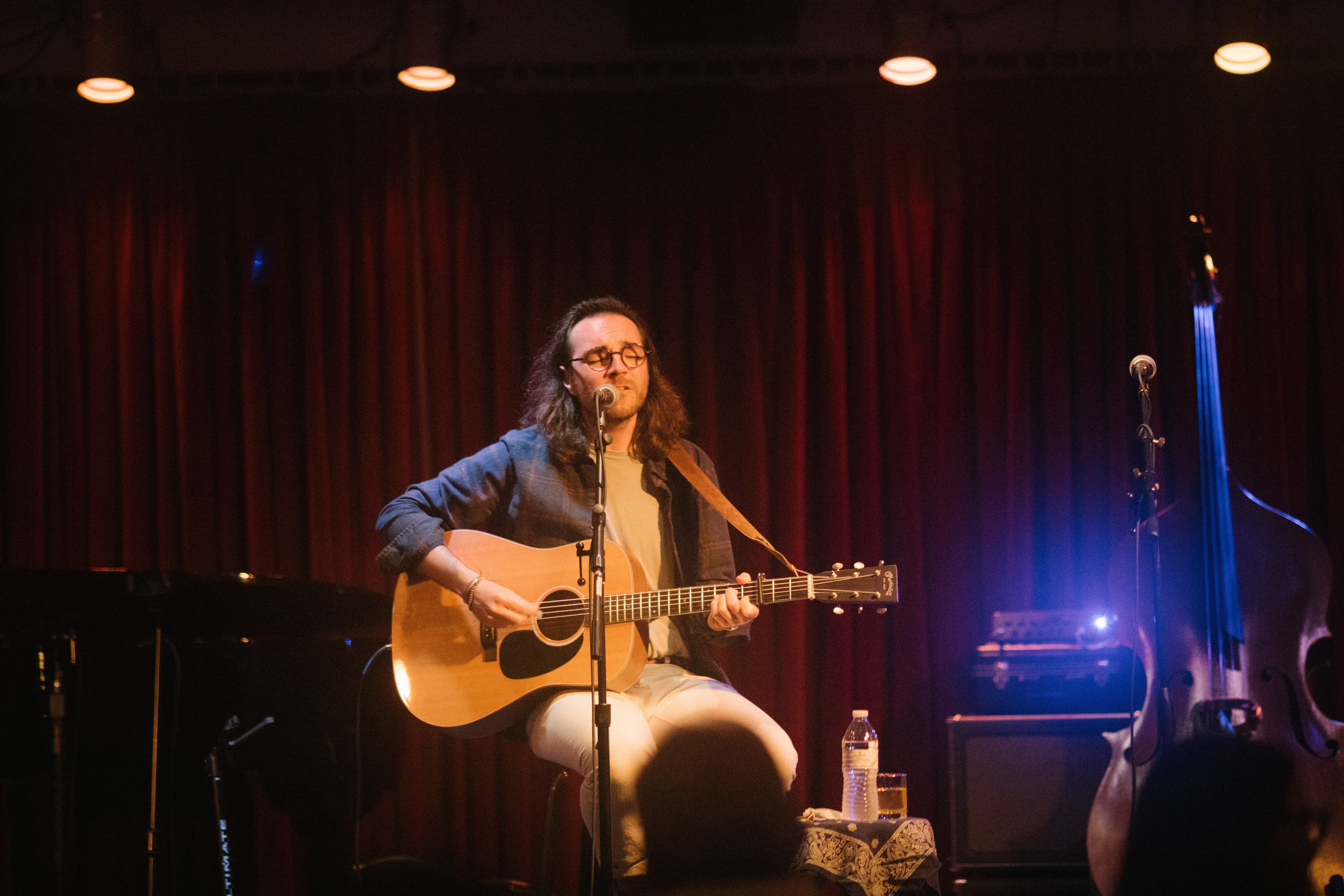 a man playing an acoustic guitar on stage