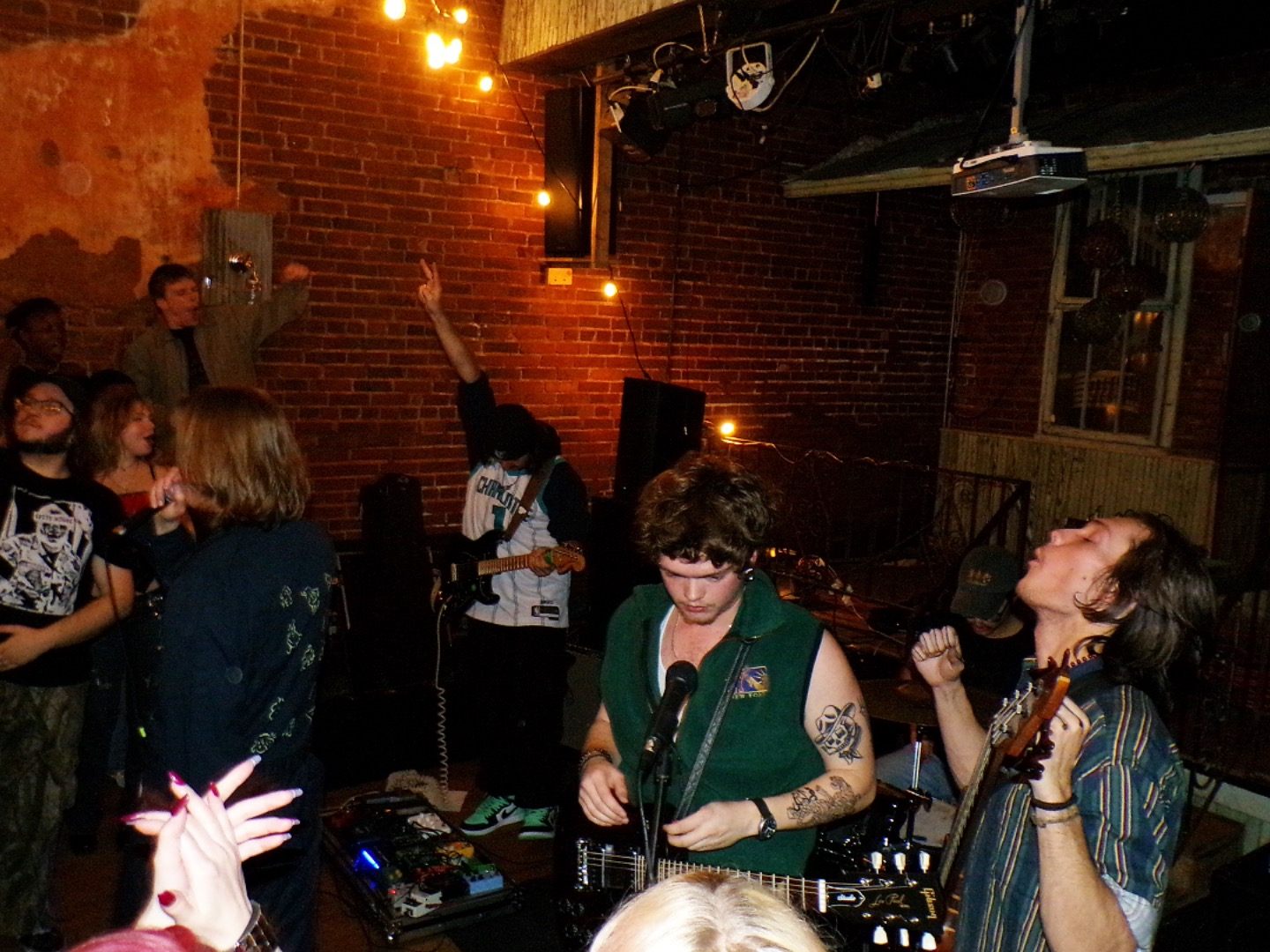 a group of people standing in front of a brick wall