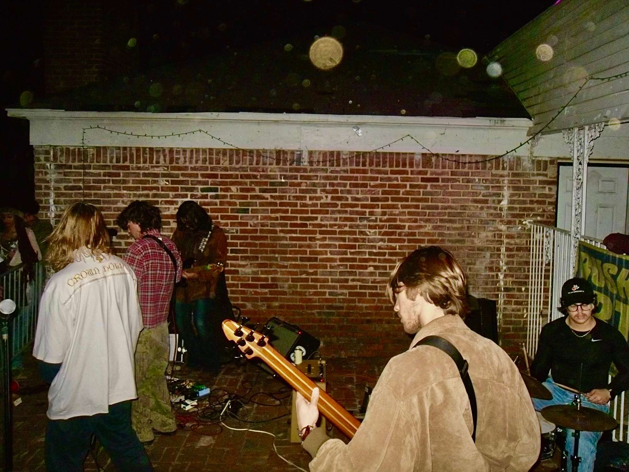 a group of people playing music in front of a brick house