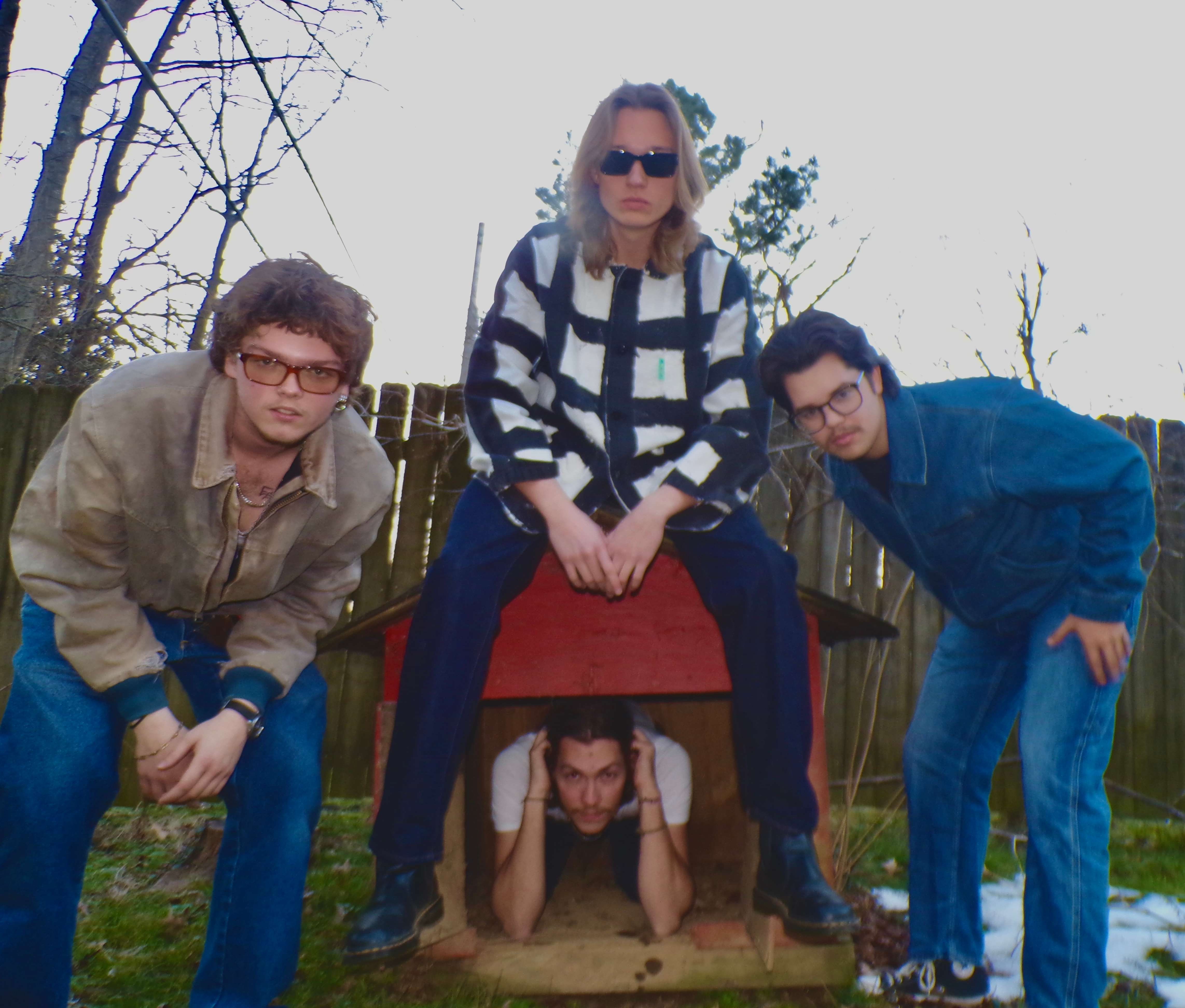 a group of people posing in front of a dog house