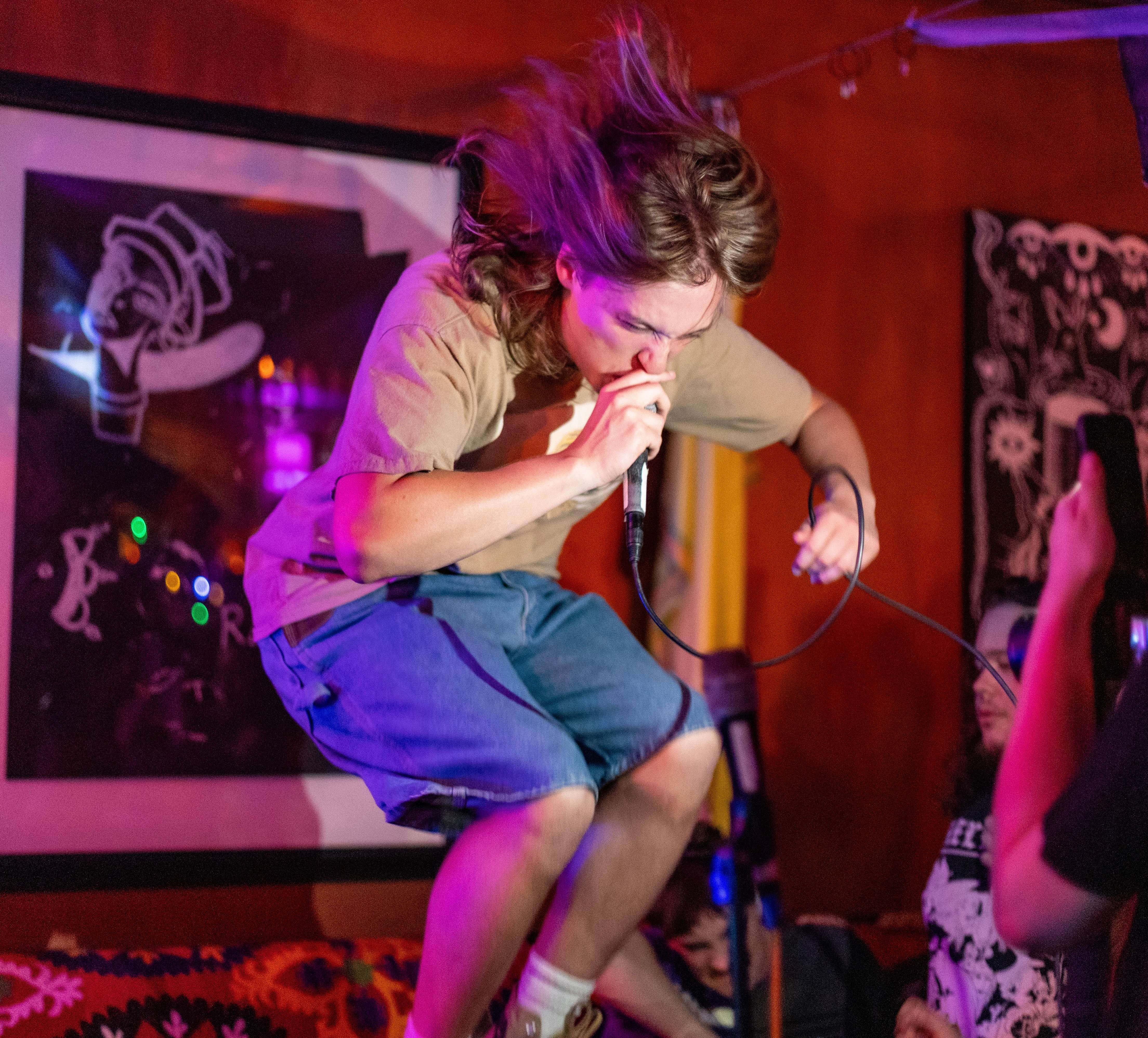 a man is jumping on a stage while people are watching him