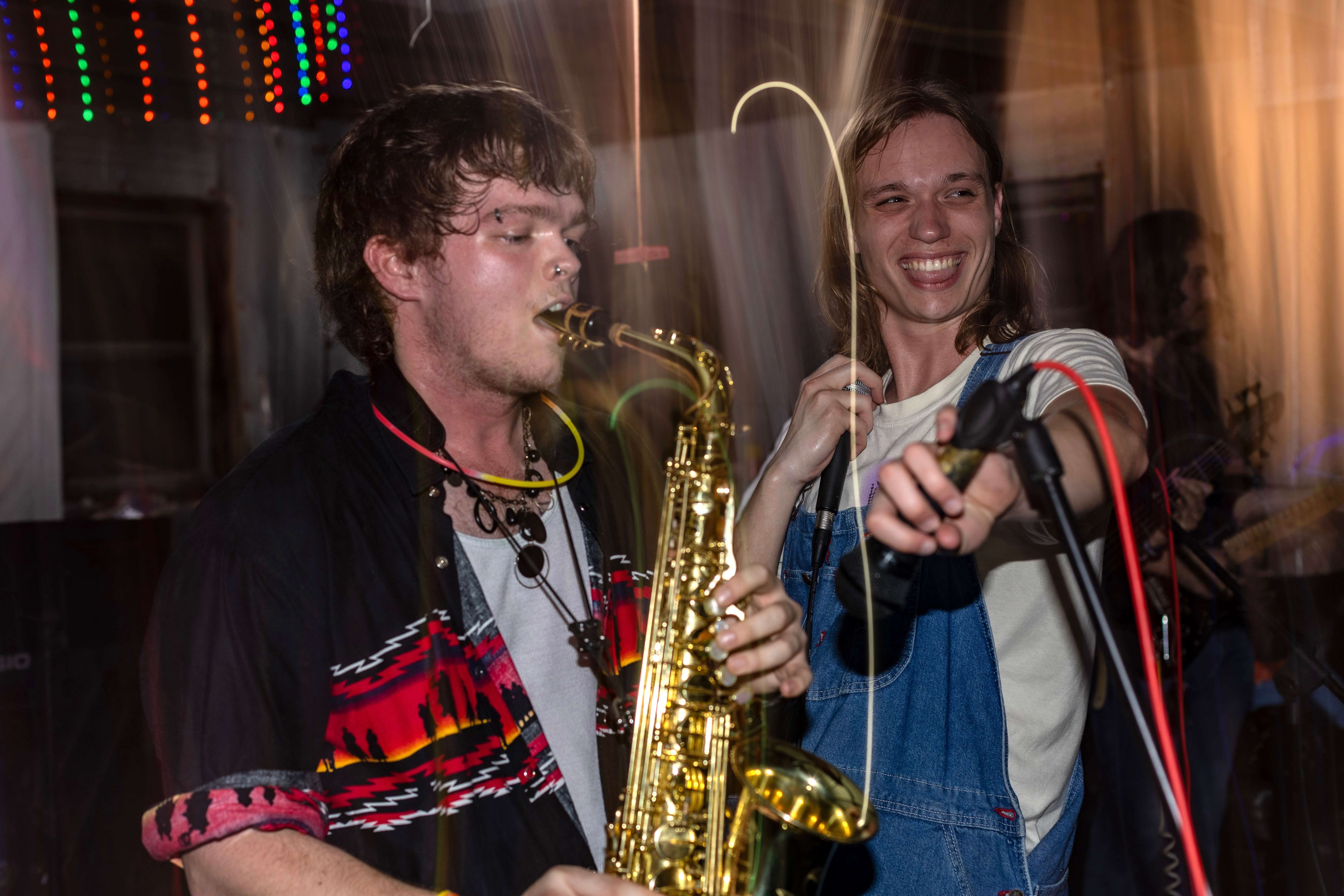 two men playing a saxophone at a party