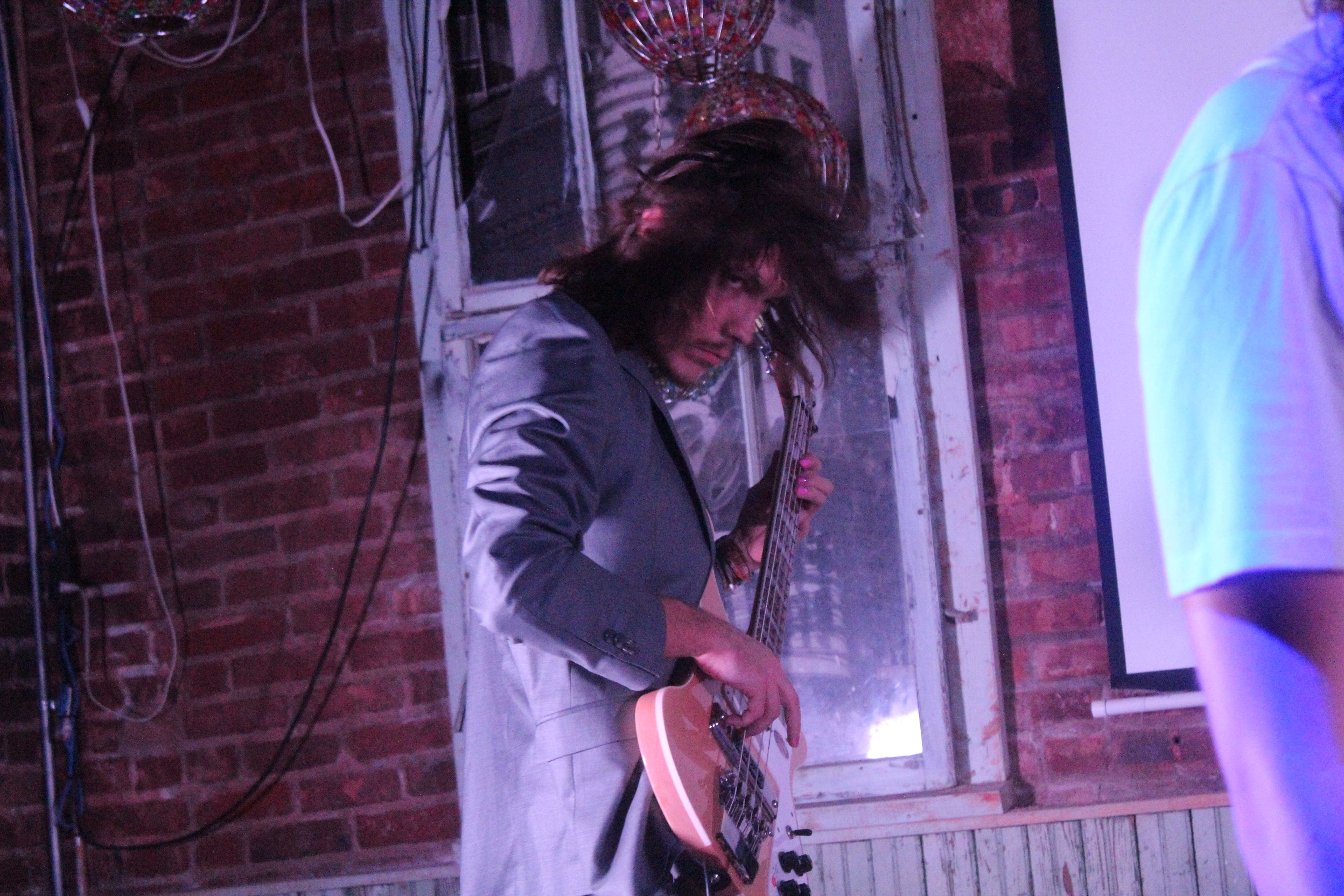 a man is playing a guitar in a room