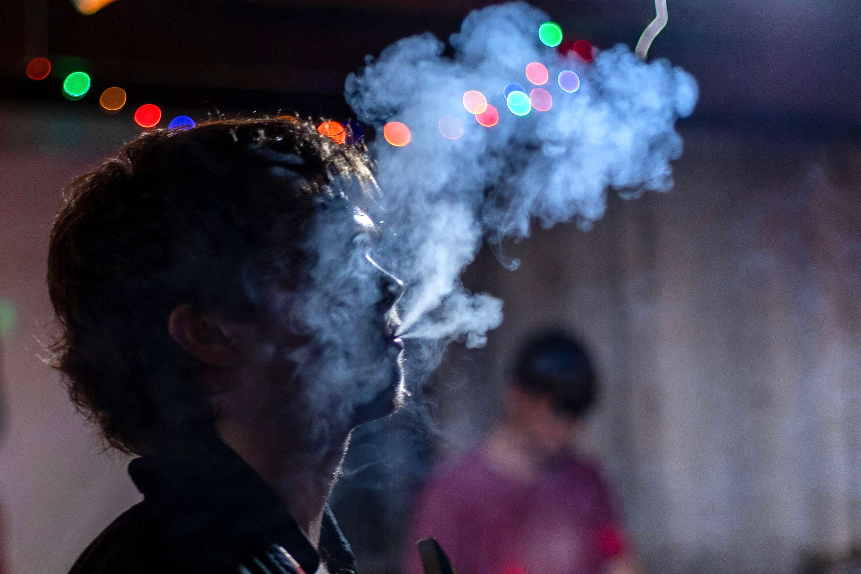 a man smokes a cigarette at a party