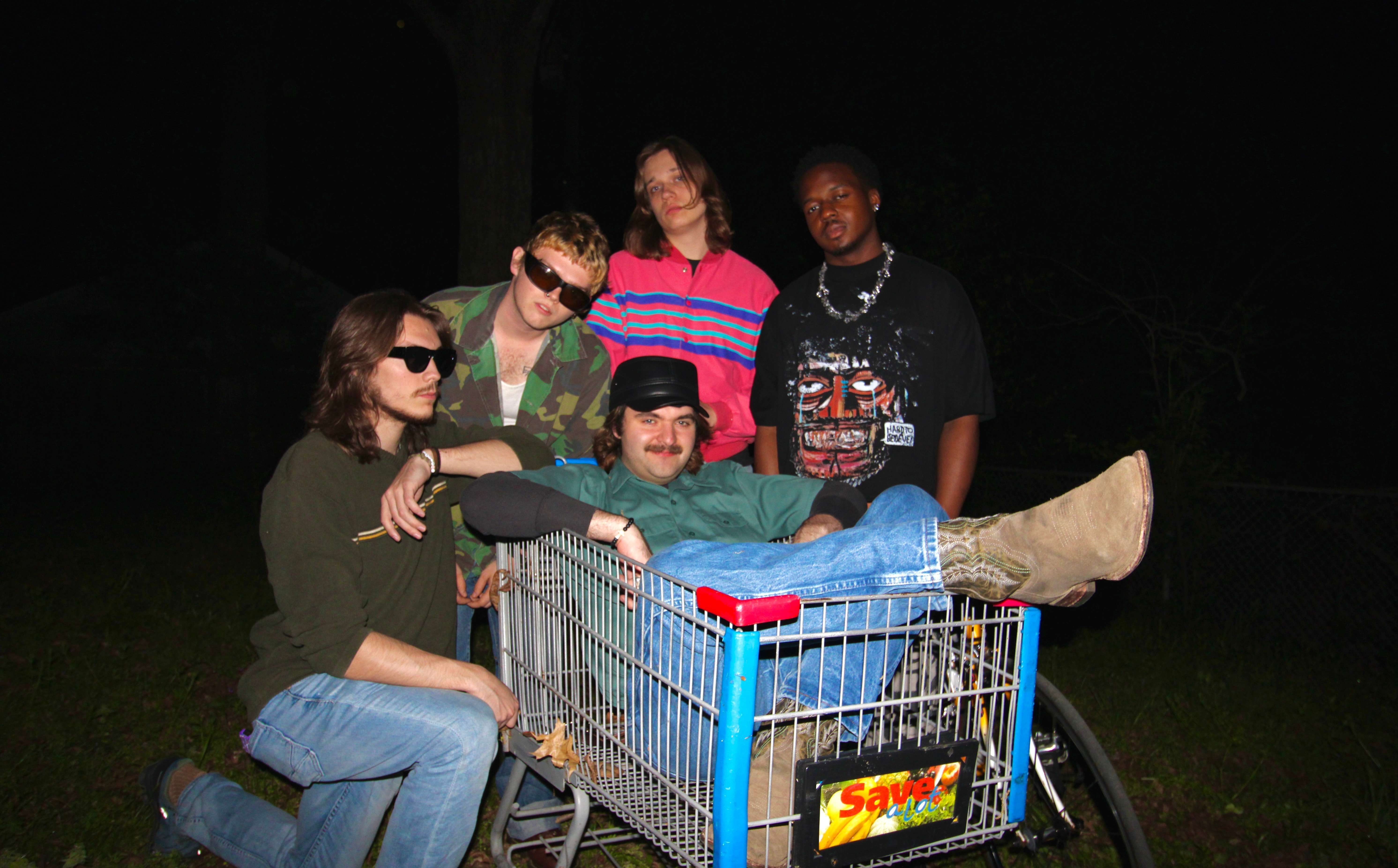 a group of people sitting in a shopping cart