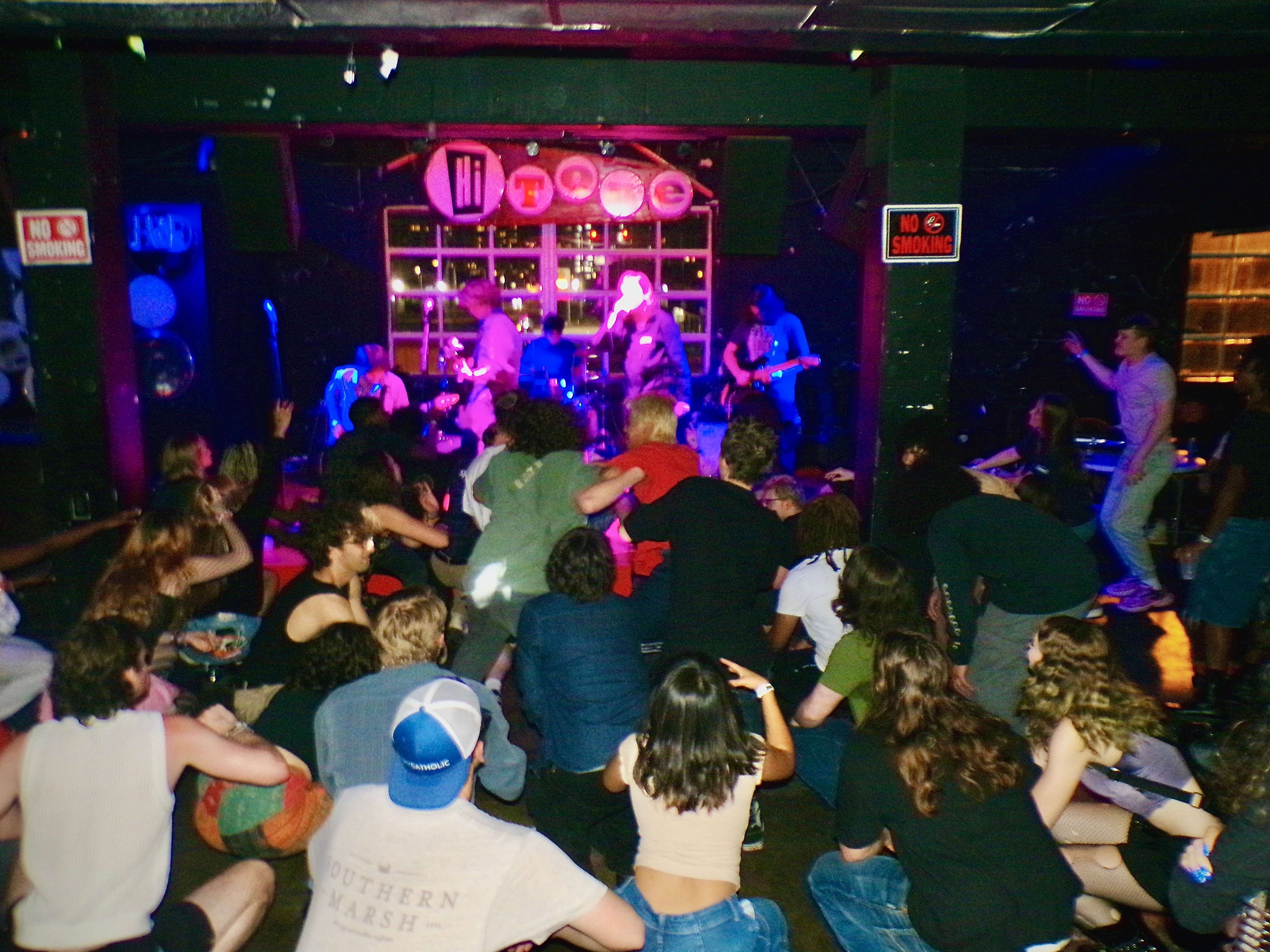 a group of people sitting on the floor in front of a stage