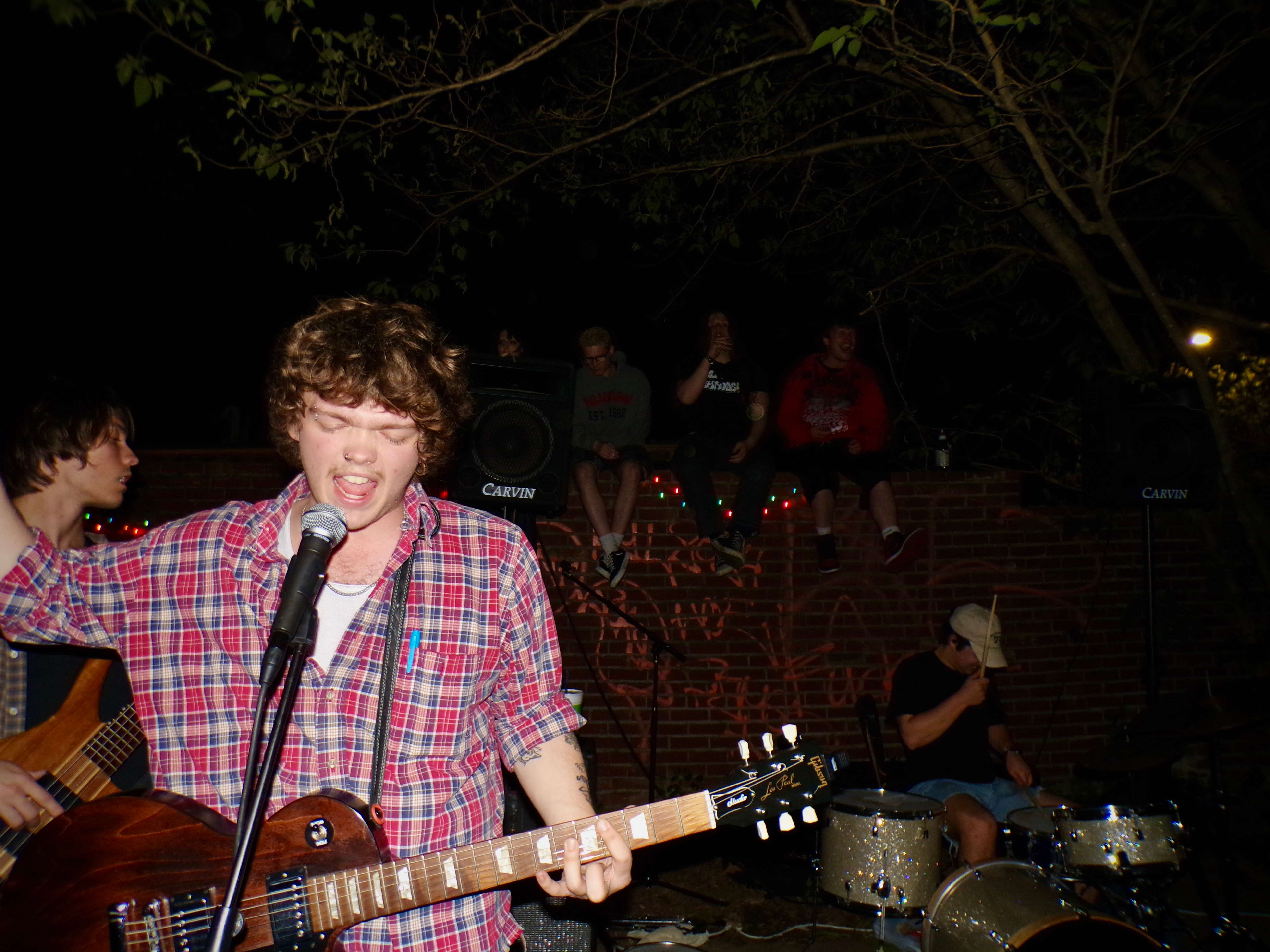 a man playing a guitar in front of a group of people
