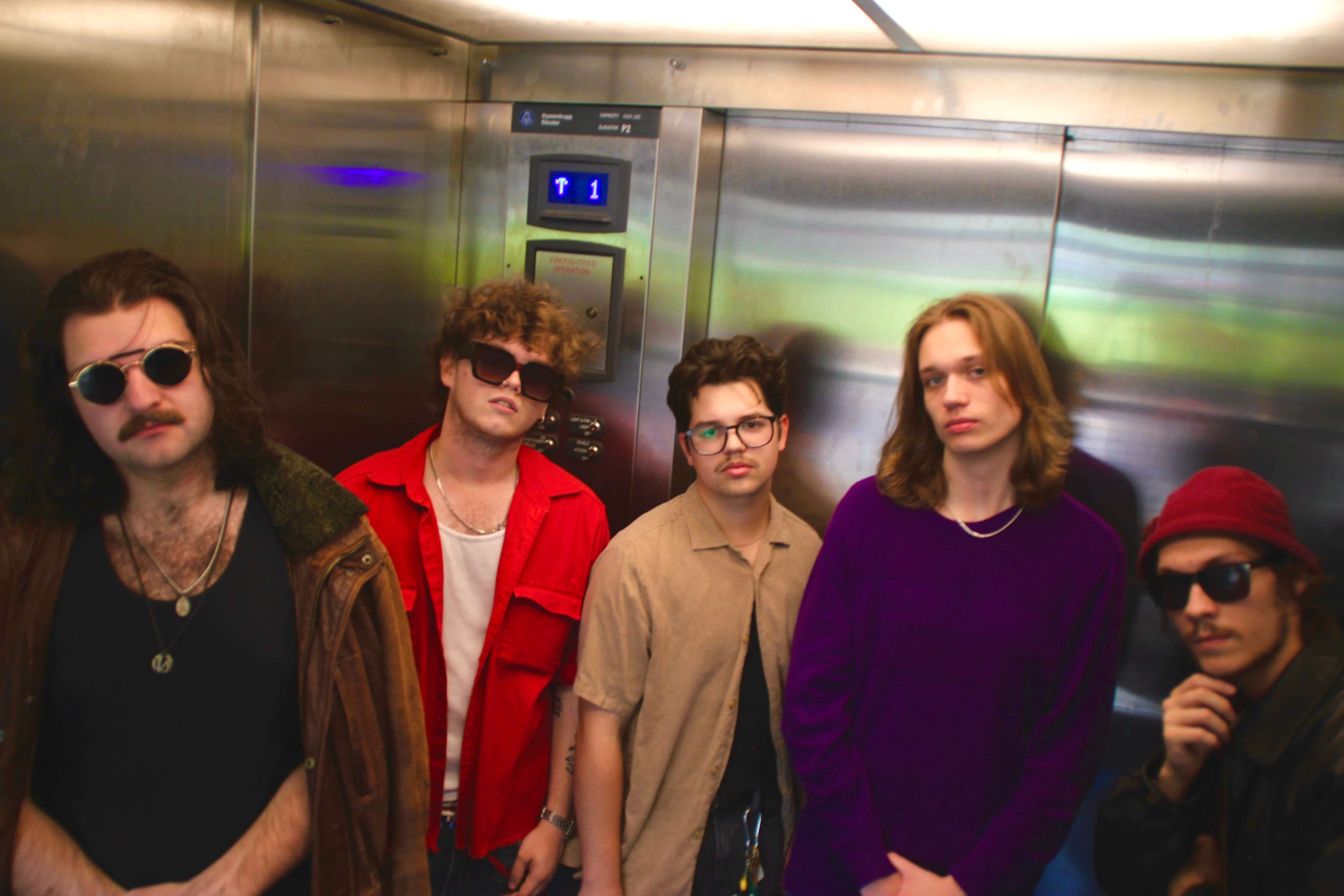 a group of young men standing in an elevator