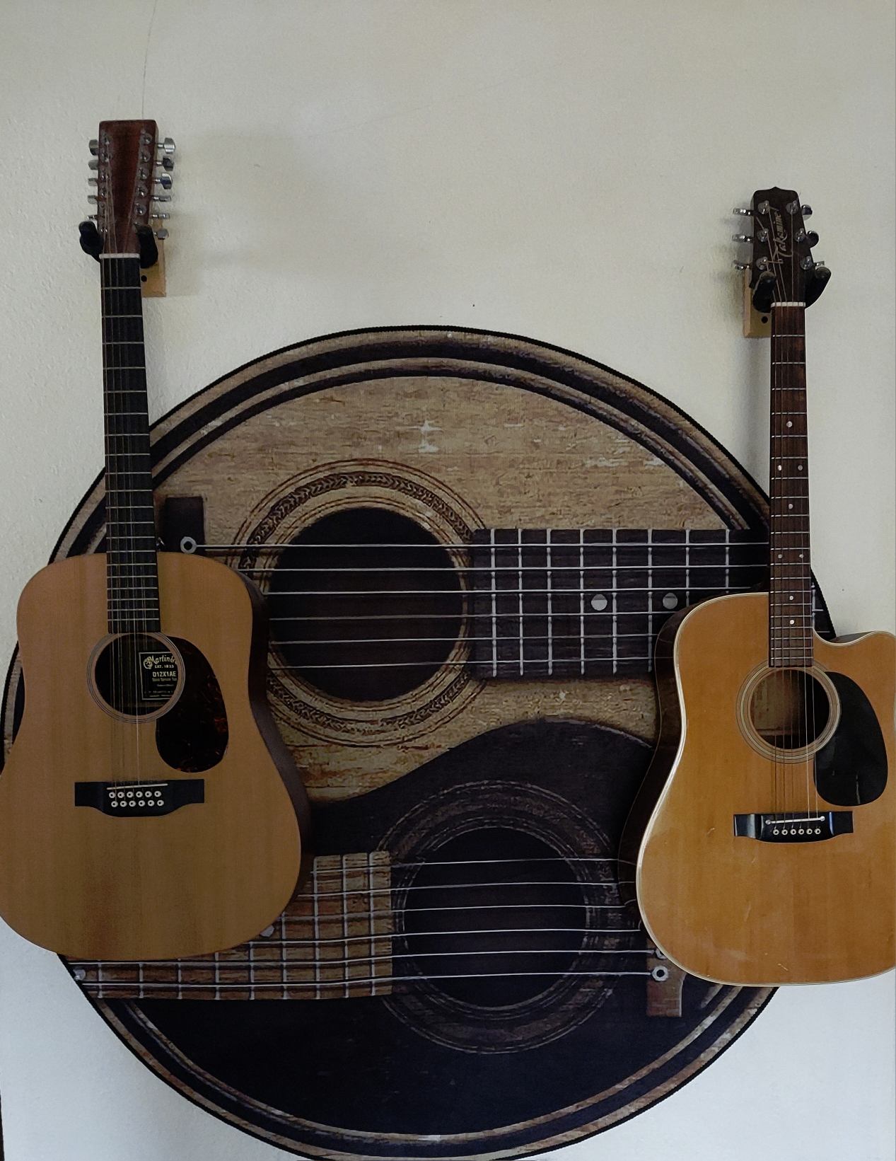 two acoustic guitars hanging on a wall