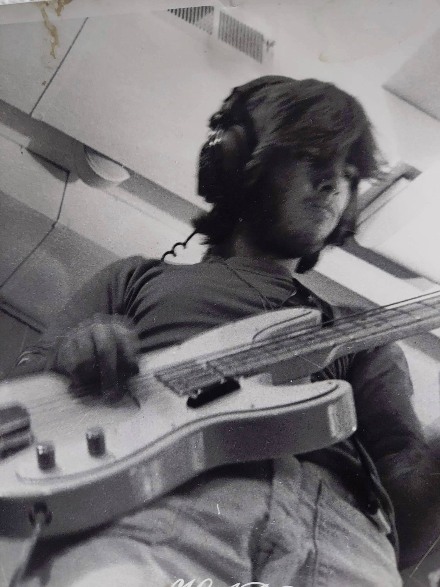 a black and white photo of a man playing a bass