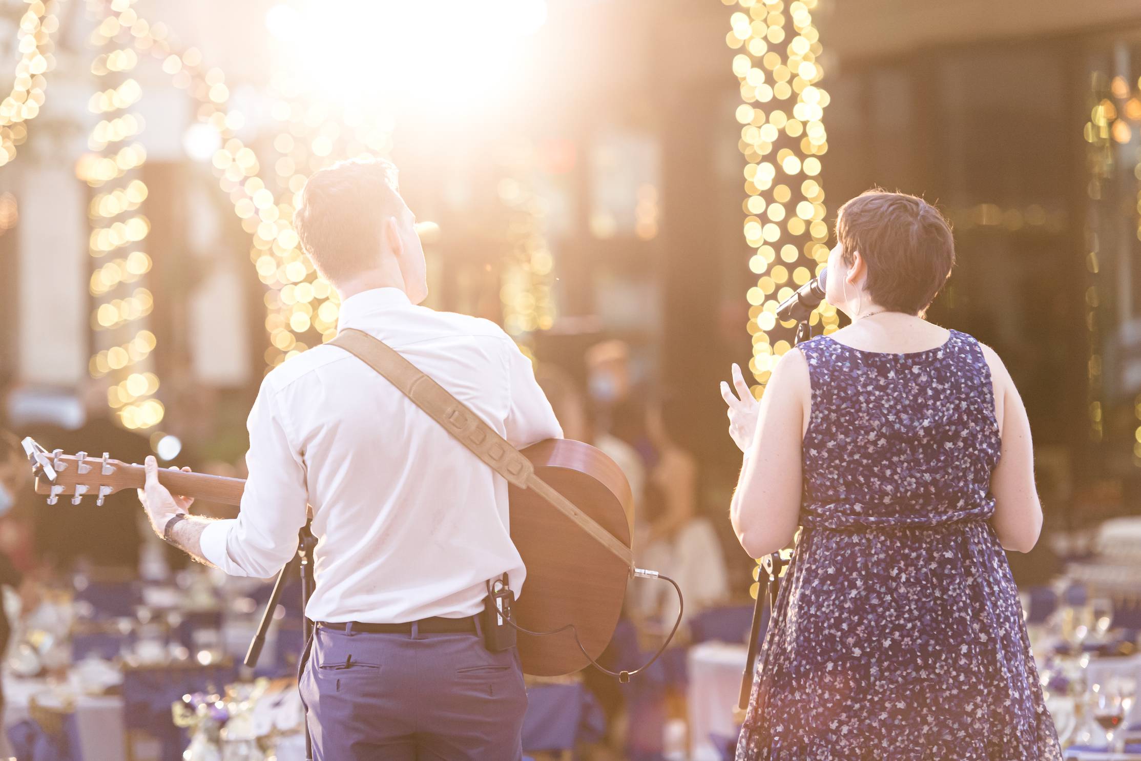a man and woman singing at an outdoor event