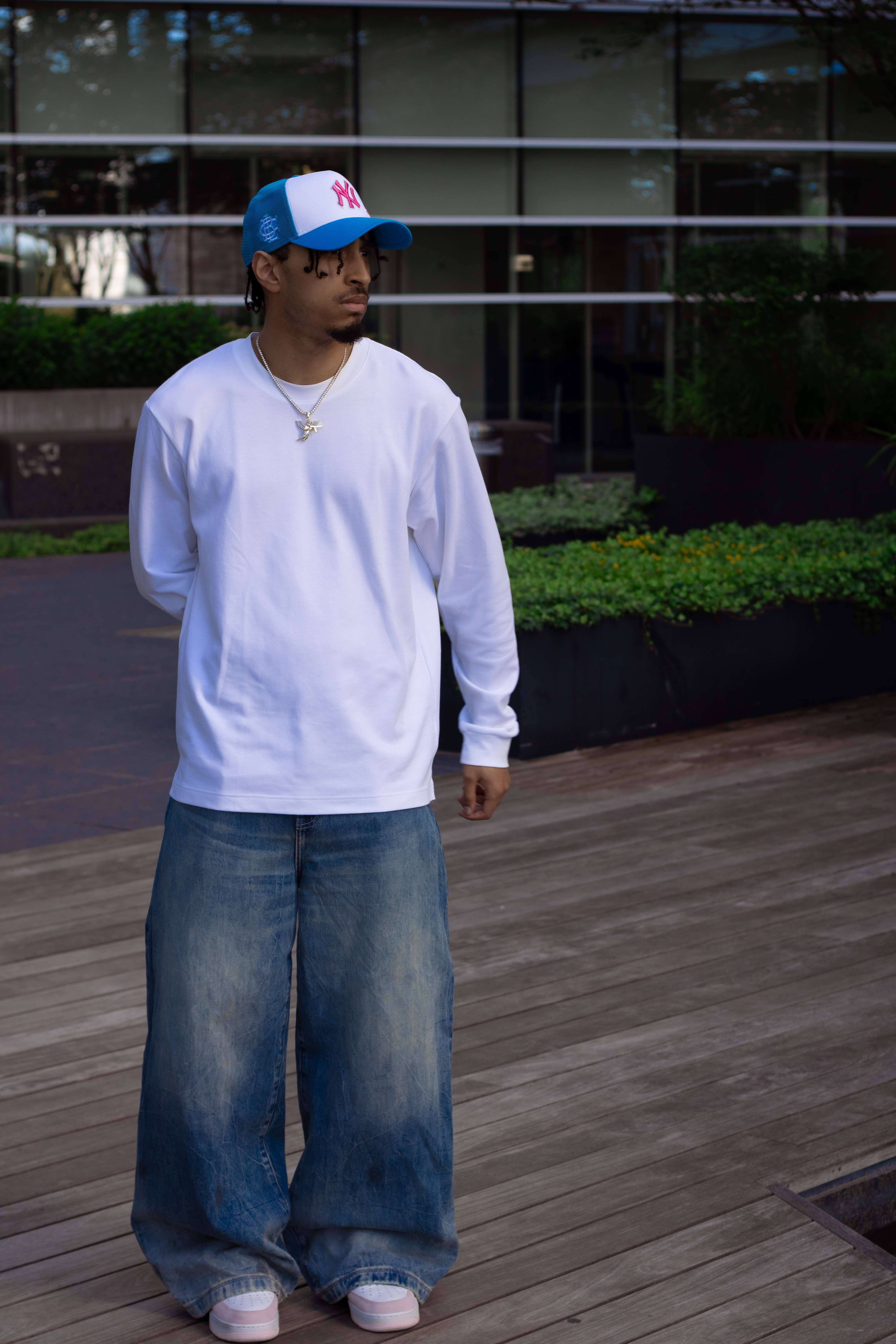 a man wearing a white t-shirt and blue jeans