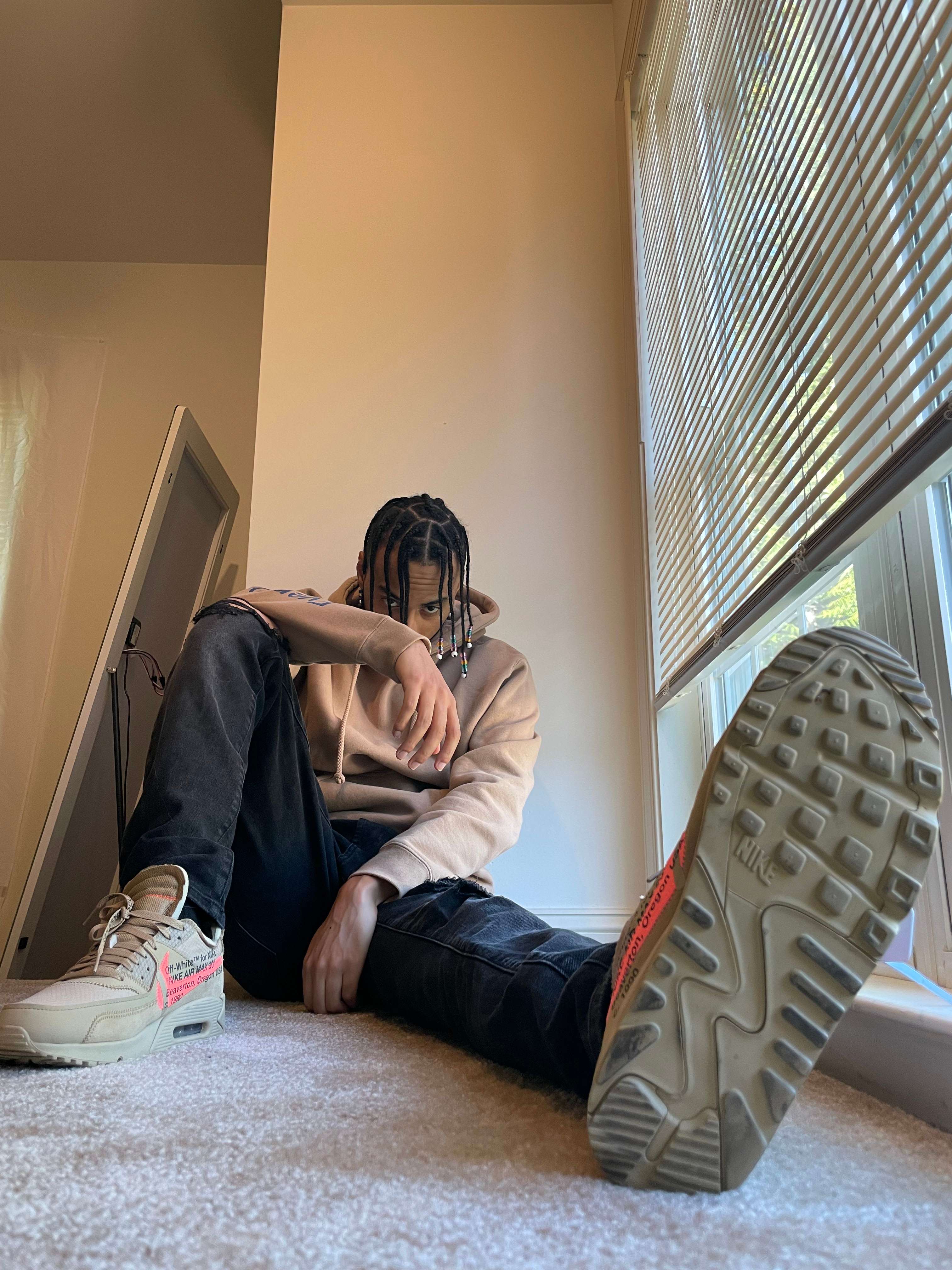 a man sitting on the floor in front of a window