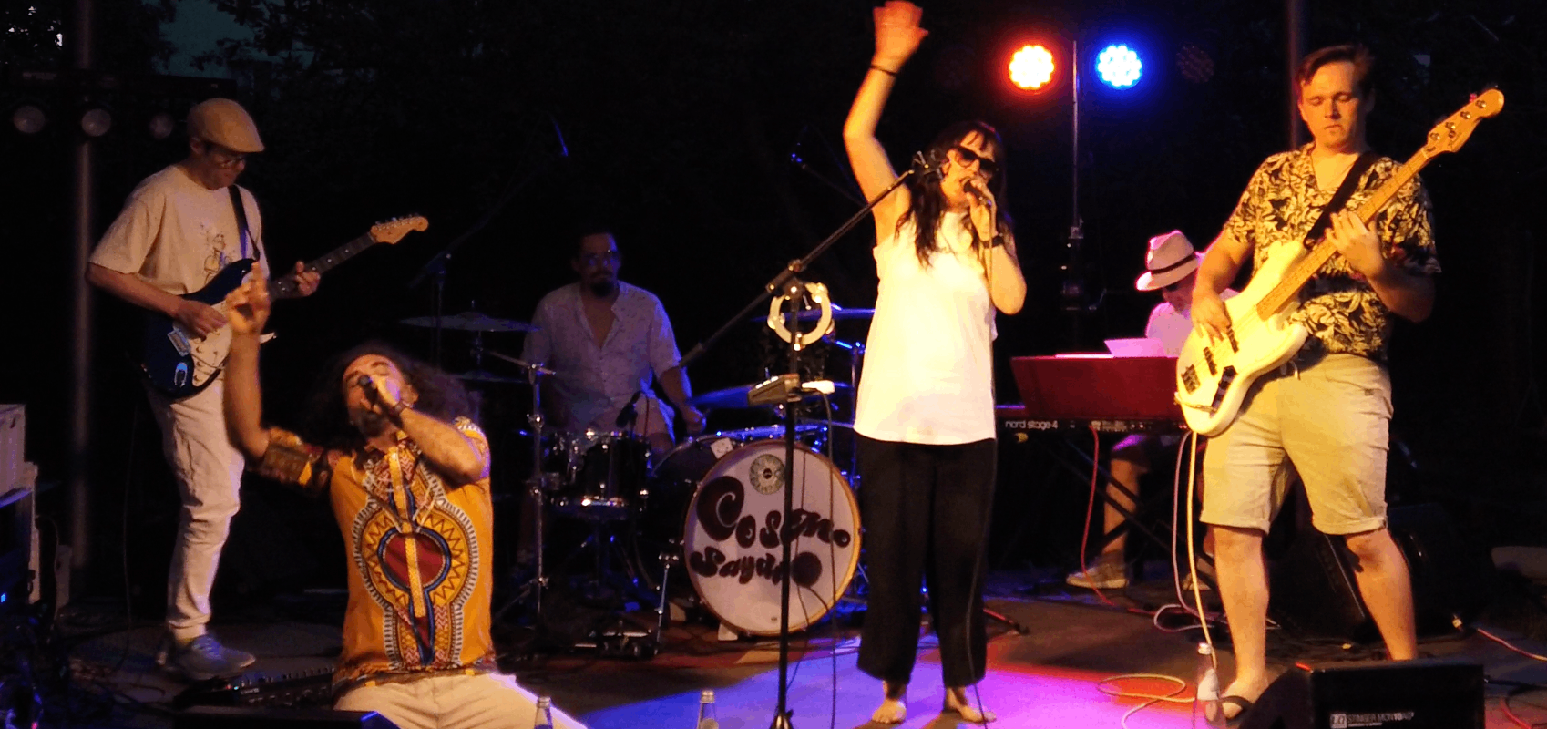 a group of people on stage with guitars and drums