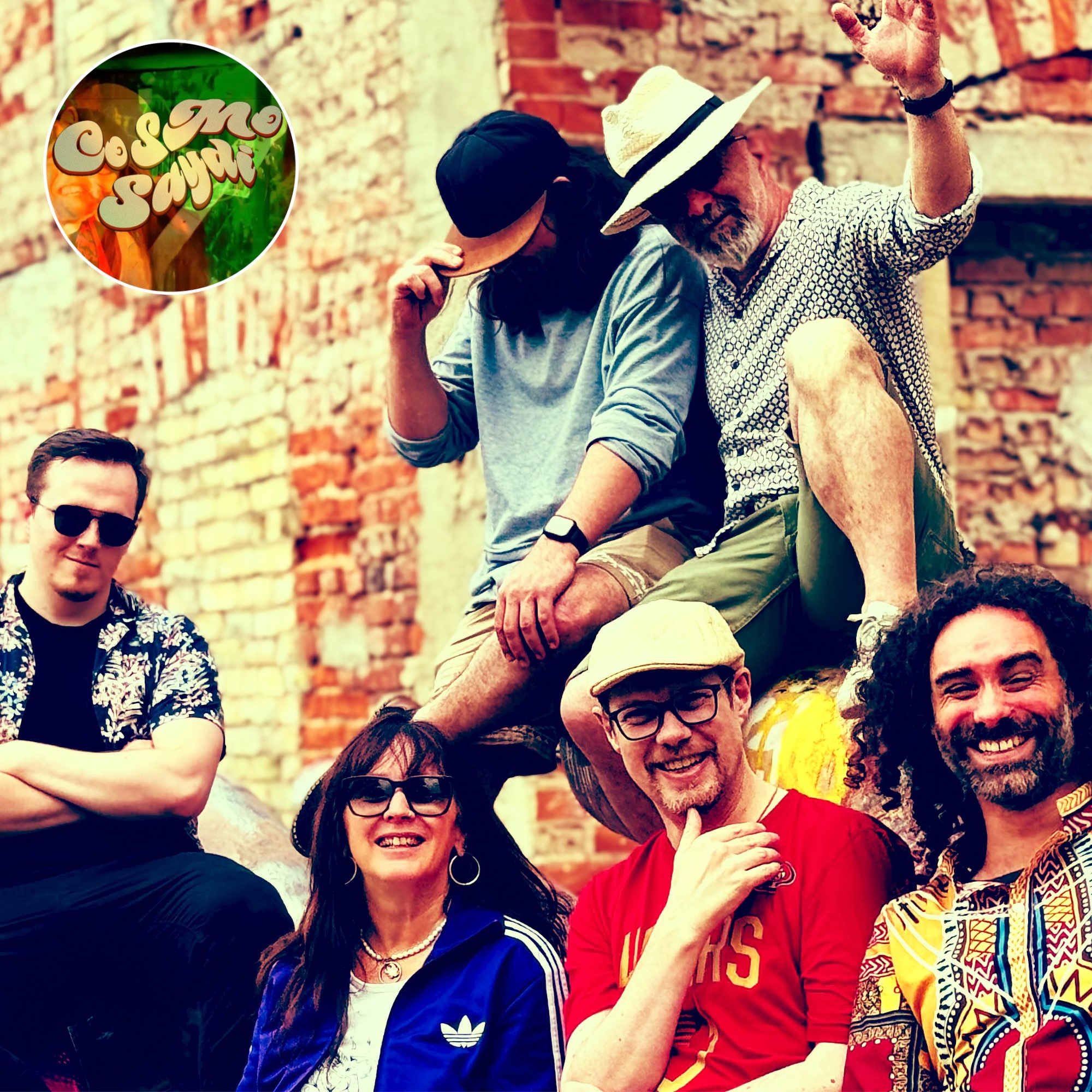 a group of people posing in front of a brick wall
