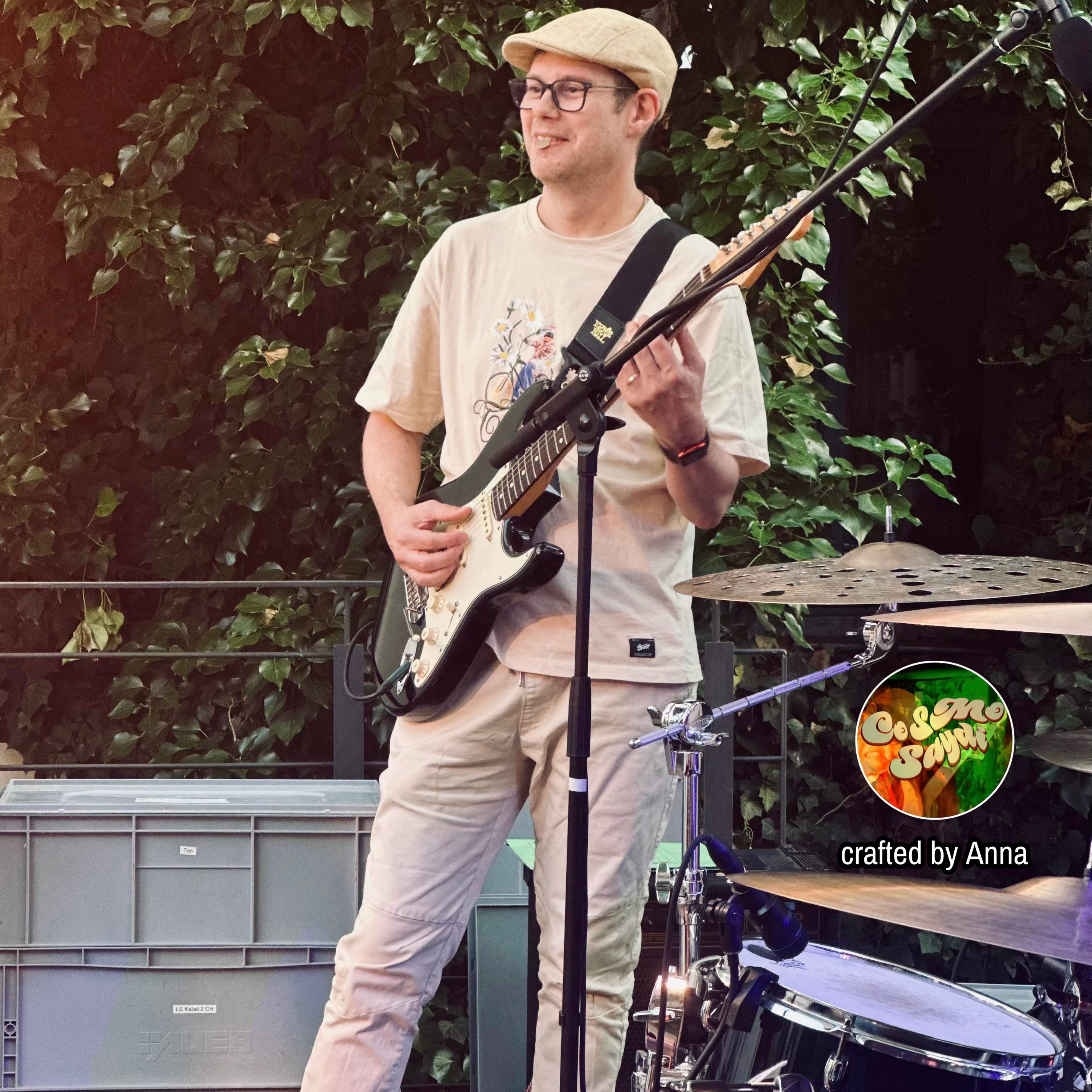 a man playing a guitar in front of a stage