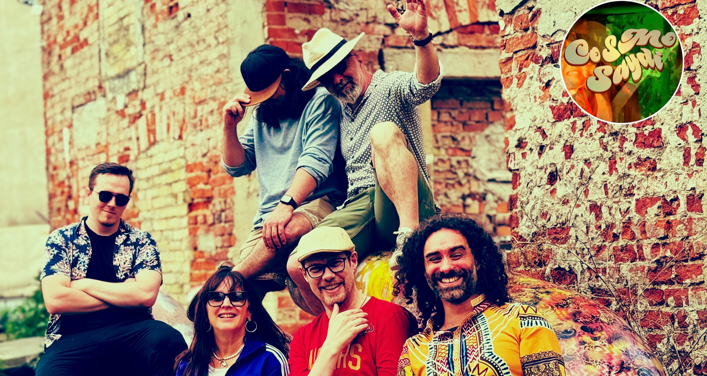 a group of people posing in front of a brick wall