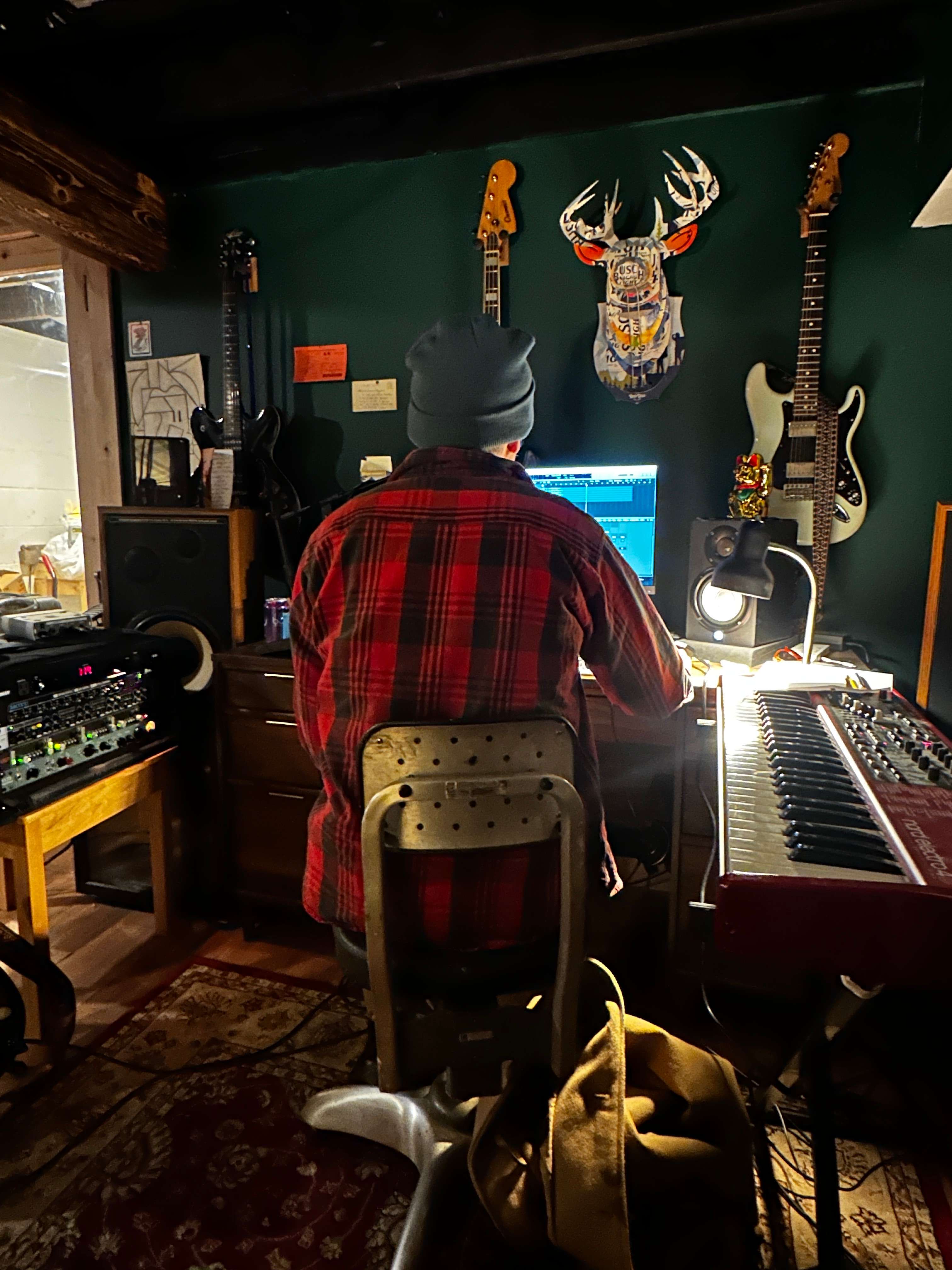 a man sitting at a desk in a recording studio