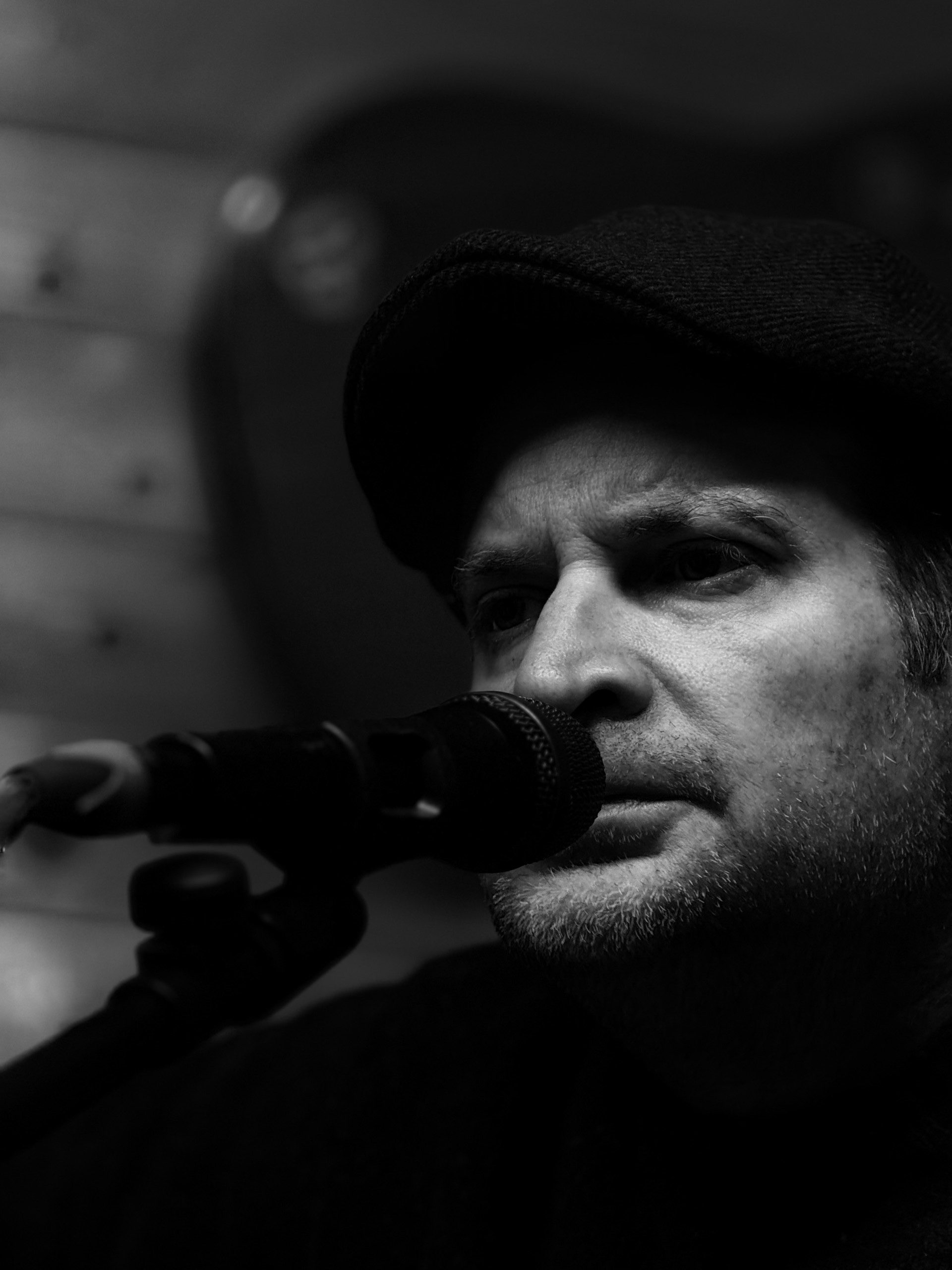 a man in a hat singing into a microphone